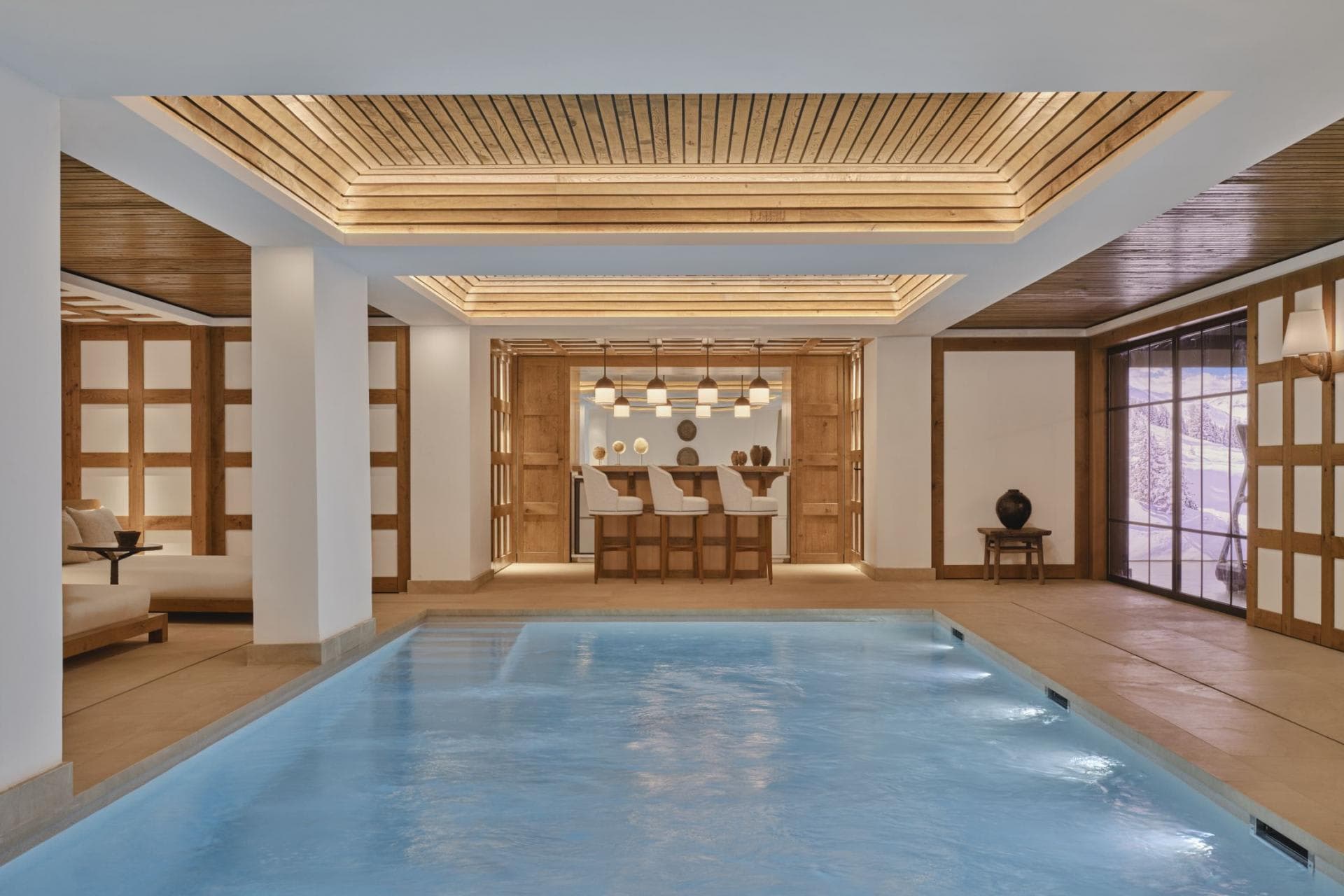 Indoor pool with heated water; reception desk and lounge areas visible beyond