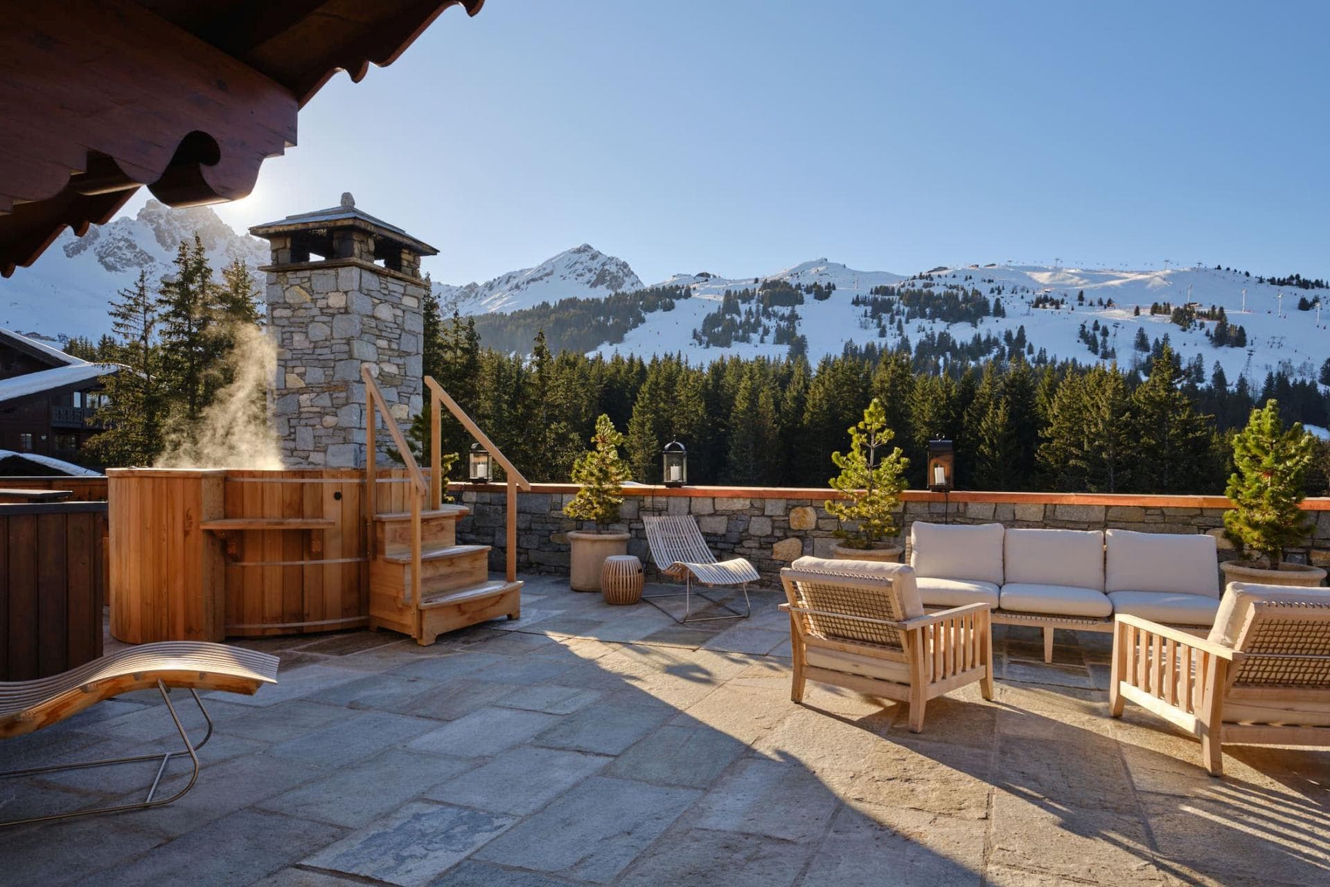 Stone terrace with cedar hot tub and mountain peak views