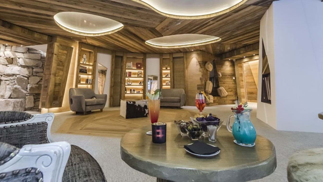 Lounge with reclaimed wood paneling and built-in library shelves