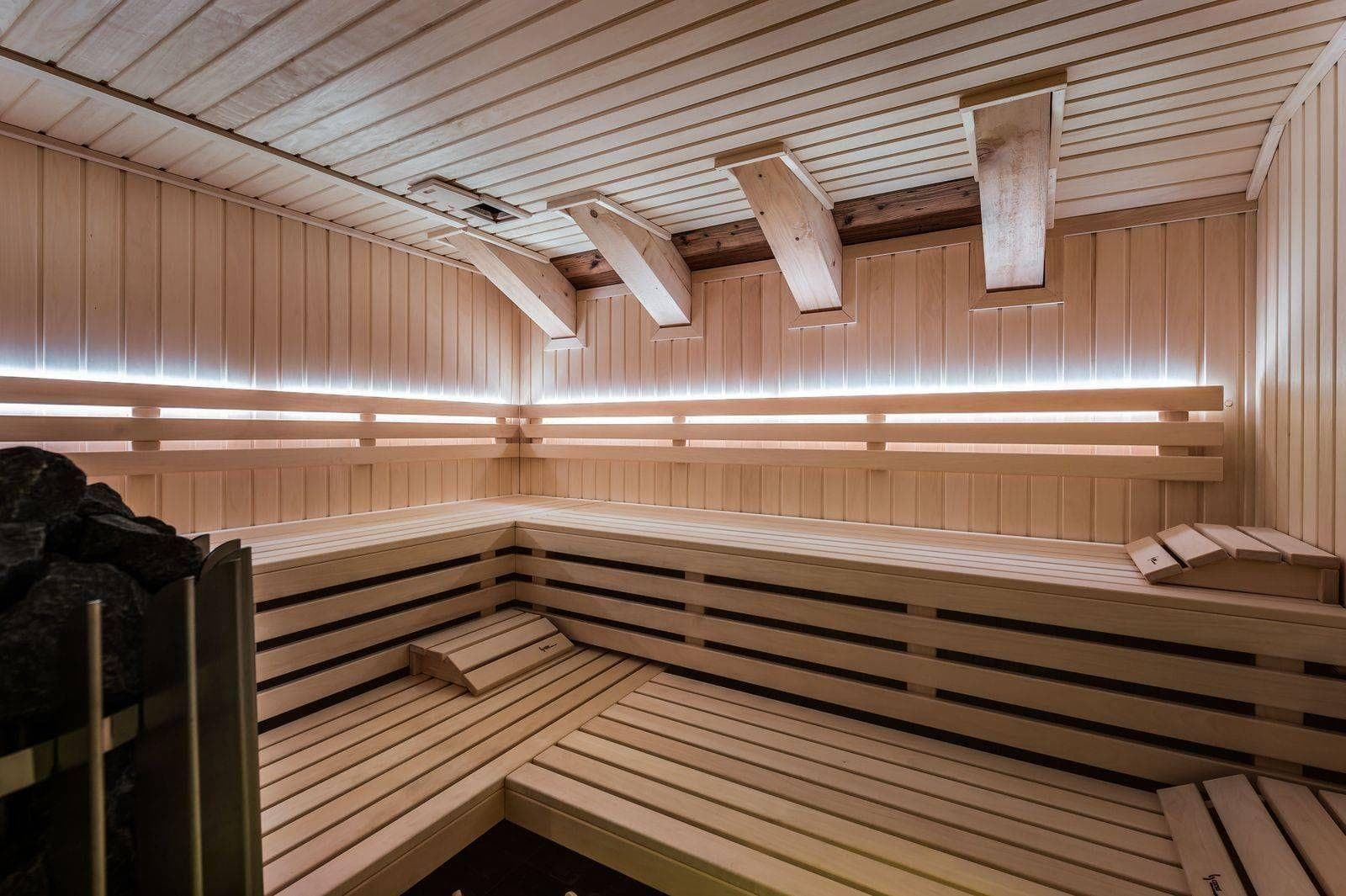 Sauna with multi-tier wood seating and integrated LED backlighting