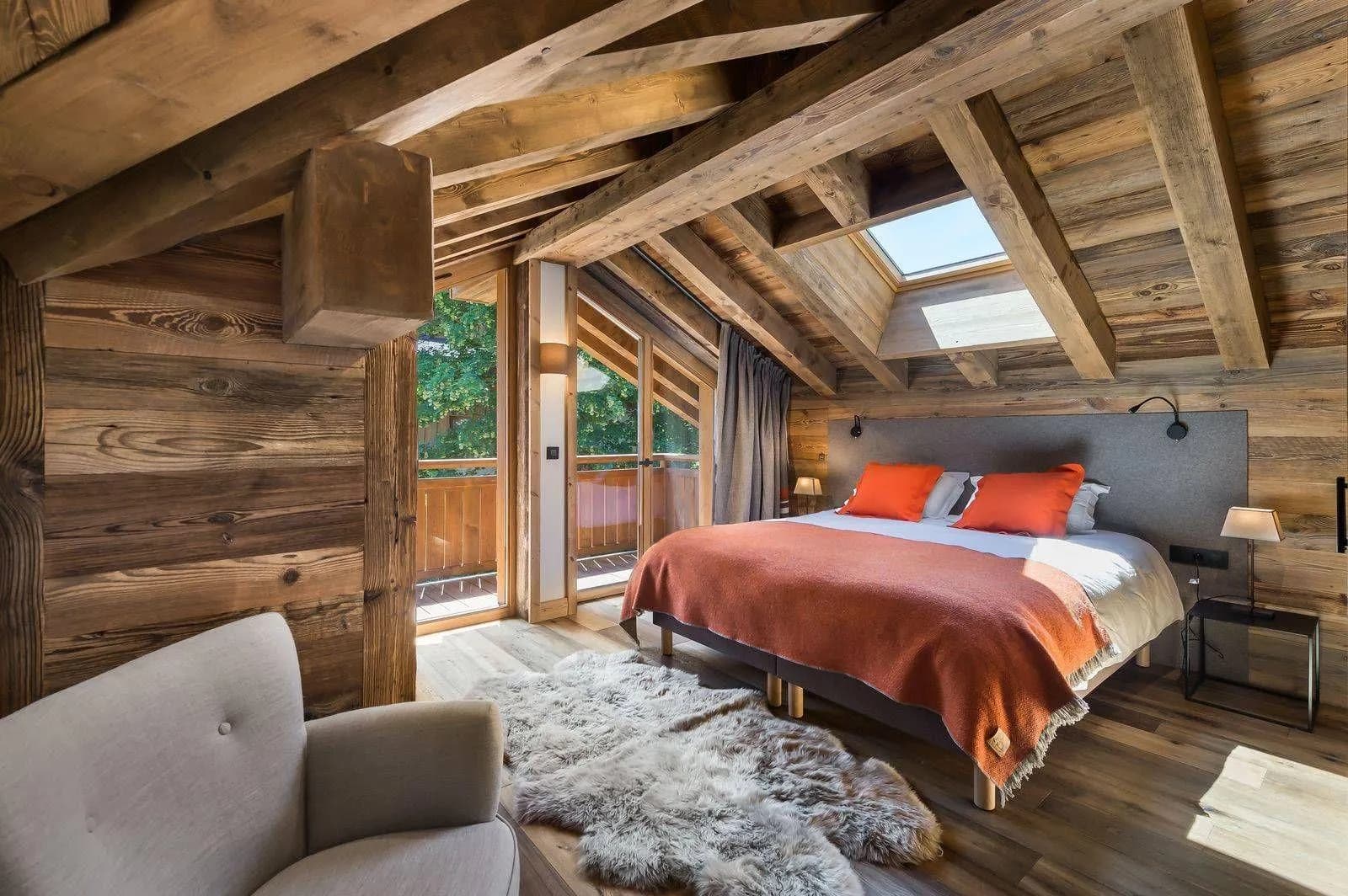Double bedroom beneath timber beams with skylight