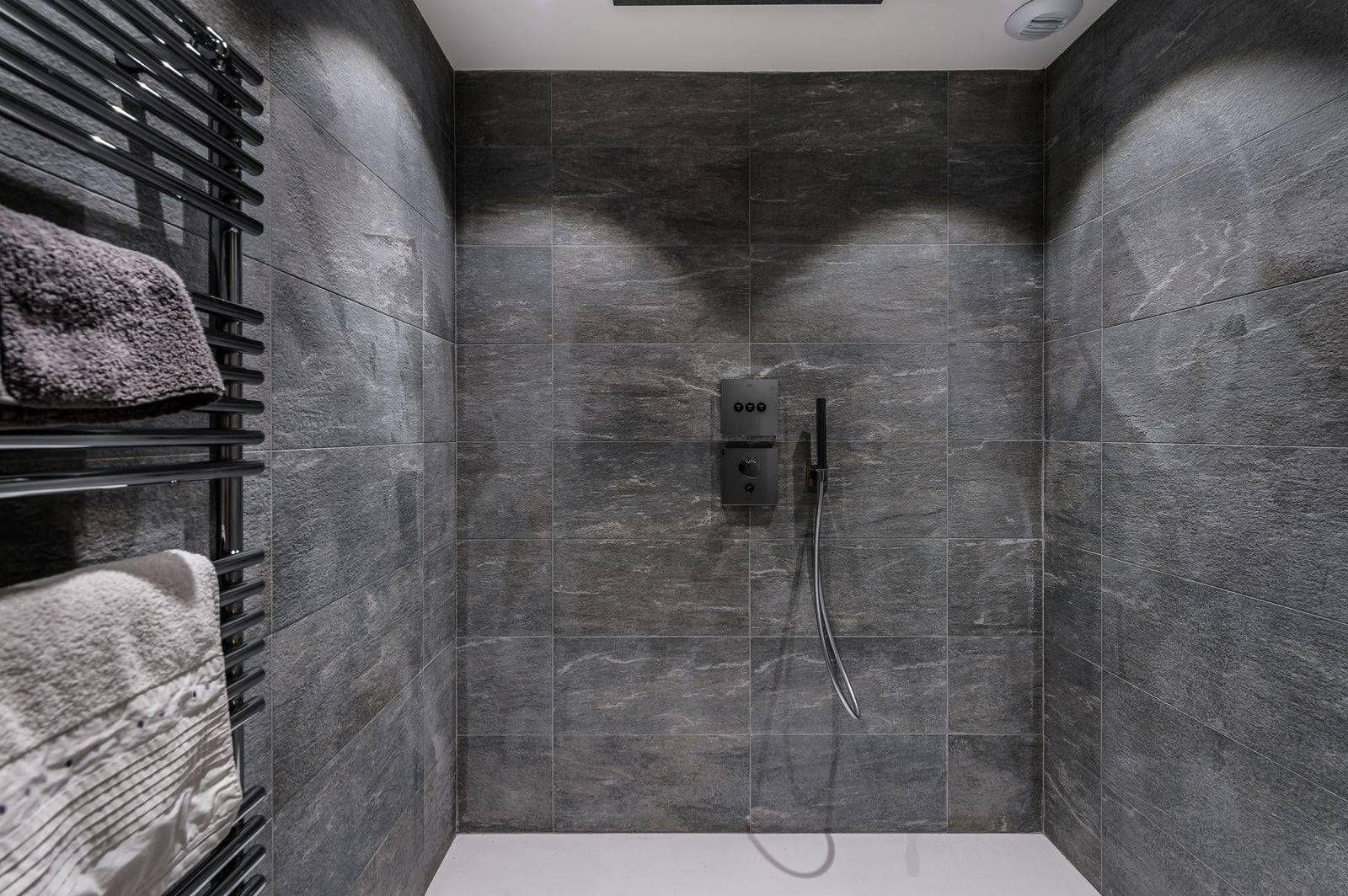 Stone shower enclosure with fixed showerhead