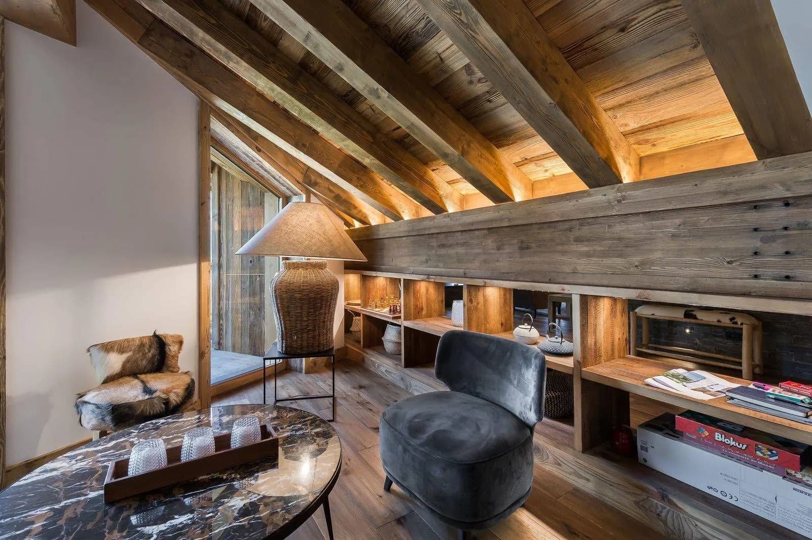 Reading lounge beneath timber beams beside the fireplace