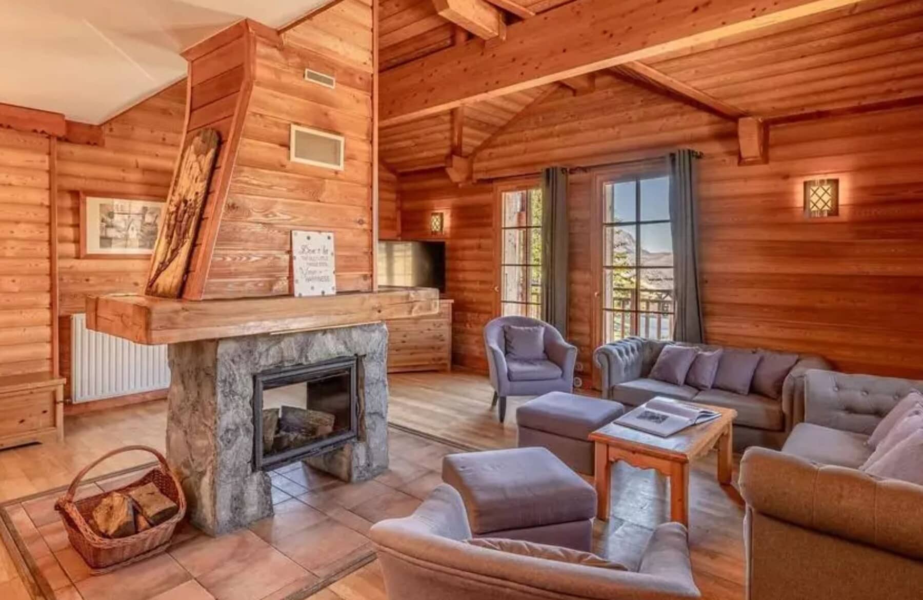 Living area with wood-burning stone fireplace and mountain-view balcony