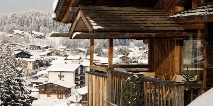 Covered wooden balcony with seating and village views