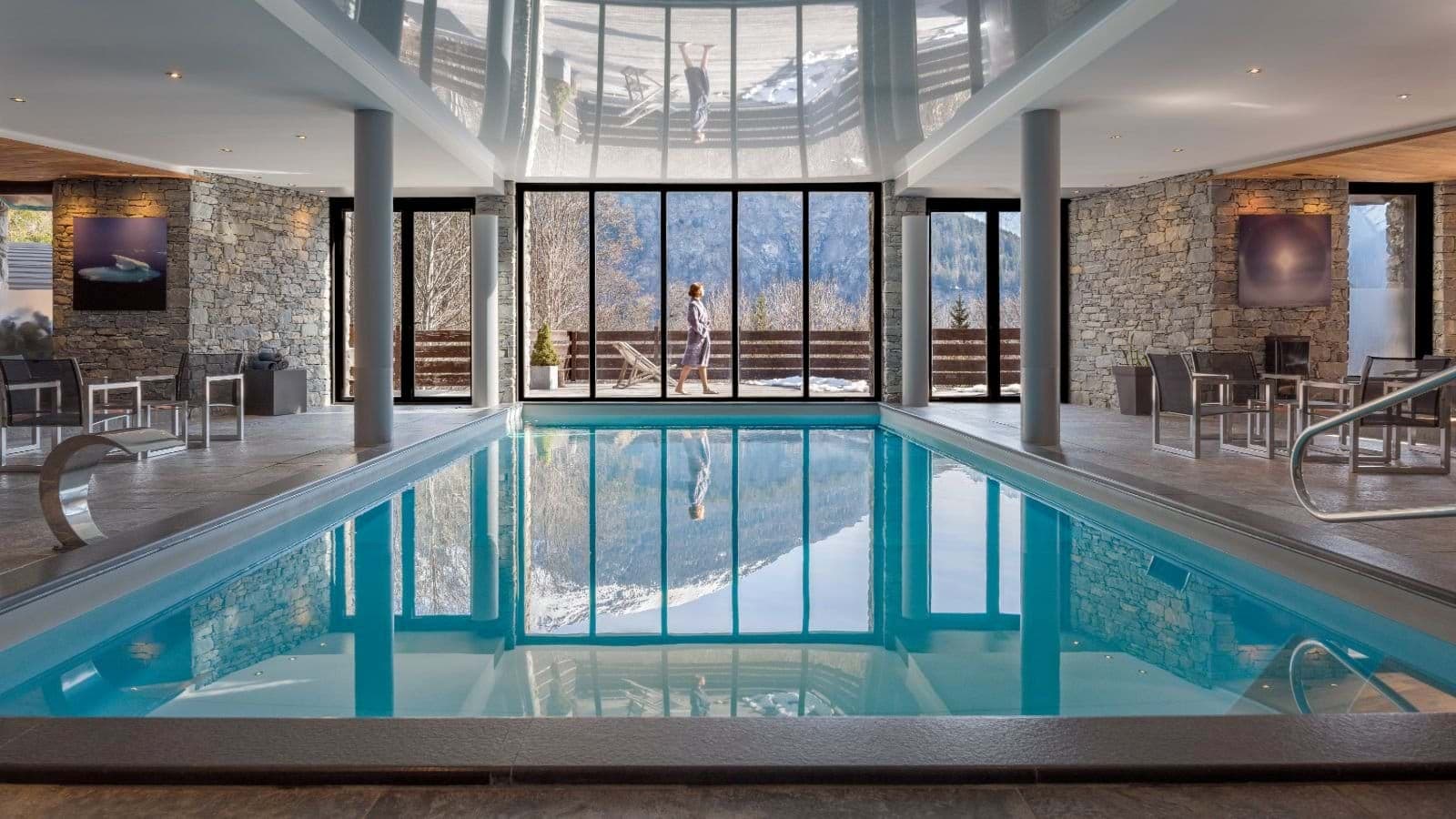 Heated indoor pool with floor-to-ceiling windows and mountain views