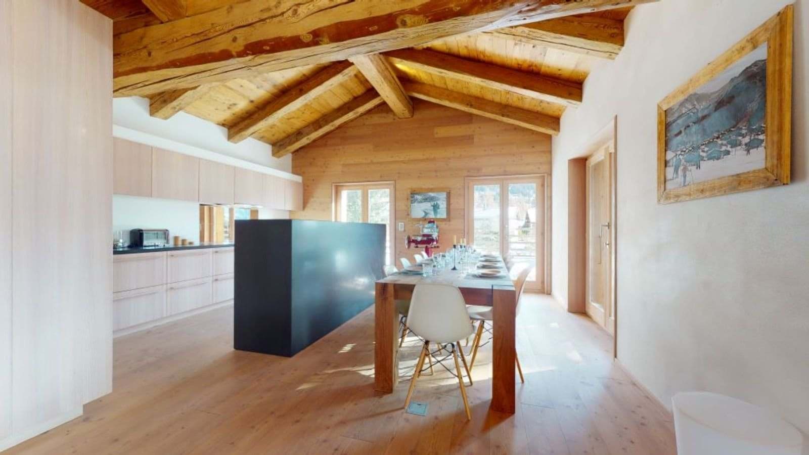 Open-plan dining area with vaulted timber ceiling and seating for 10