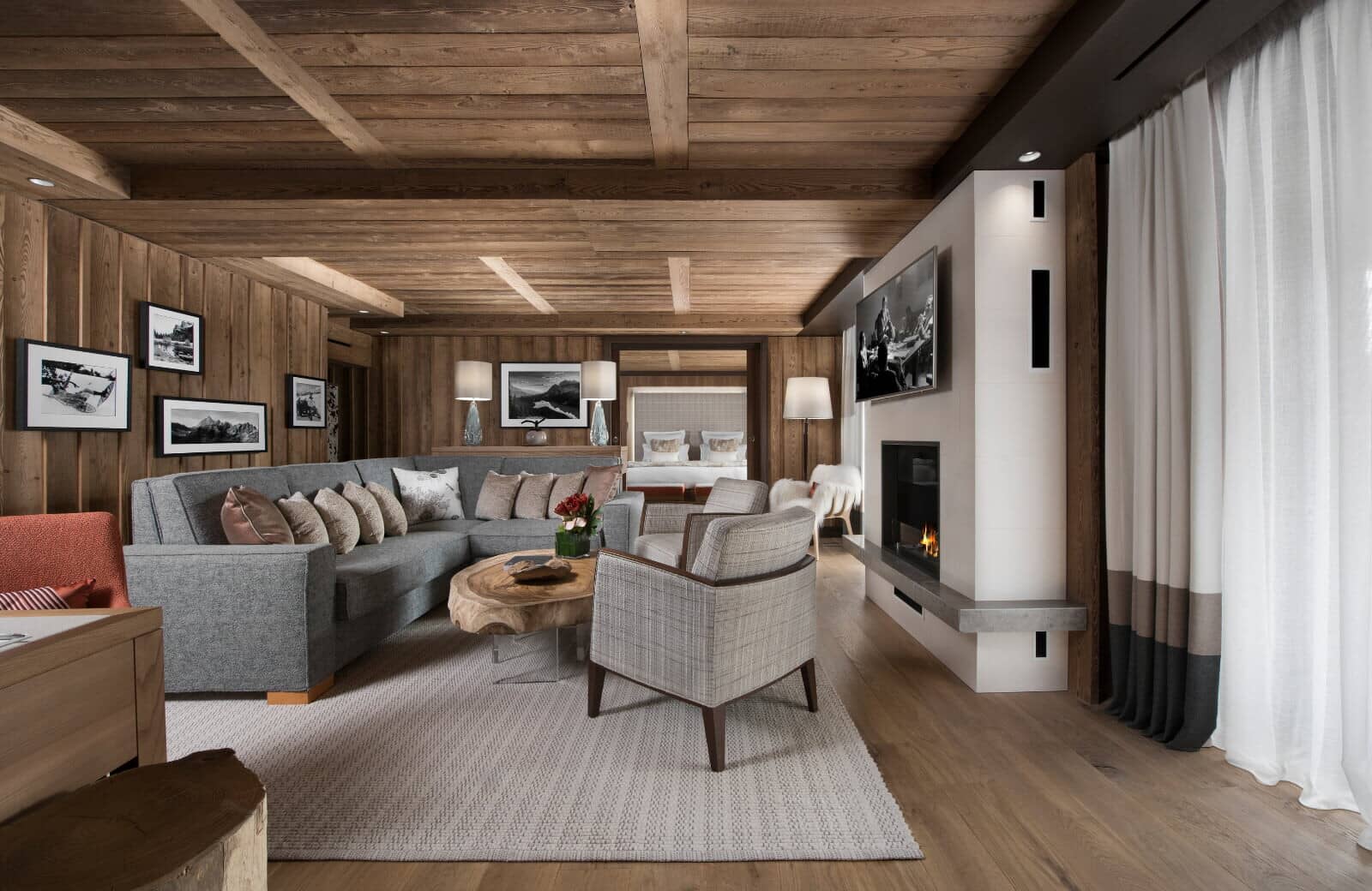 Living room with gas fireplace and wood-paneled walls and ceiling