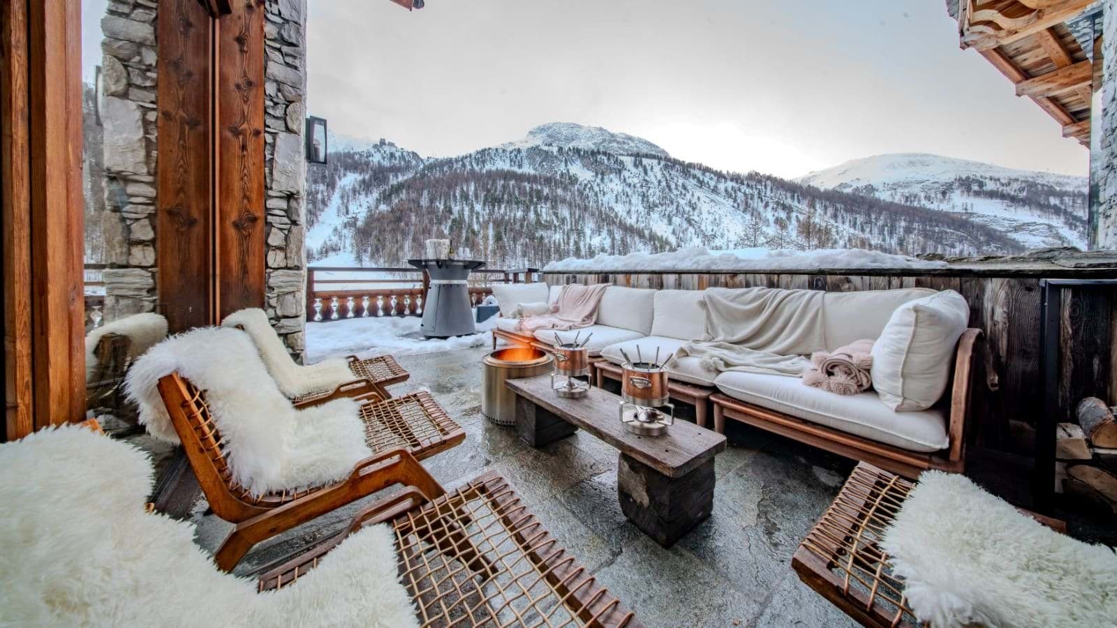 Covered terrace with fire pit, fondue sets, and mountain views
