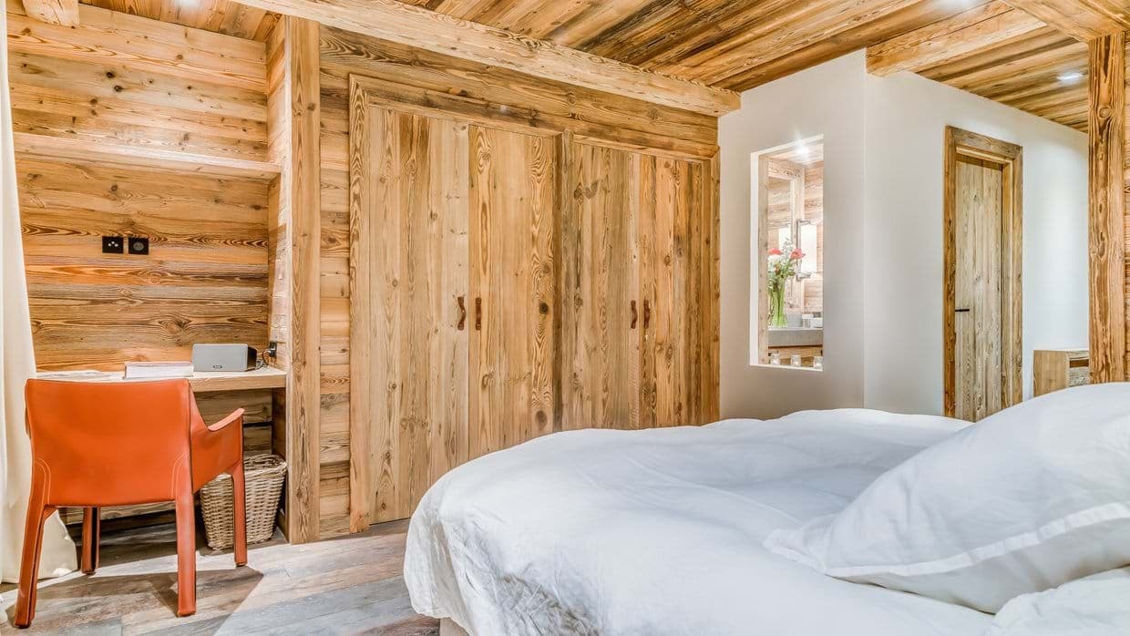 Bedroom with built-in desk and wood-paneled closets