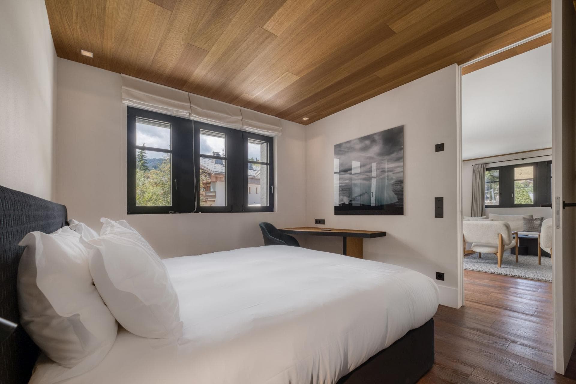 Bedroom with king bed and dedicated workspace; wood-paneled ceiling