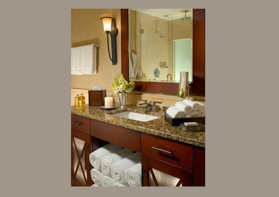 Master bathroom with dual vanity, granite countertop, and accessible towel storage