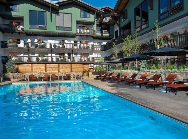 Shared pool and sun deck with lounge chairs and umbrellas