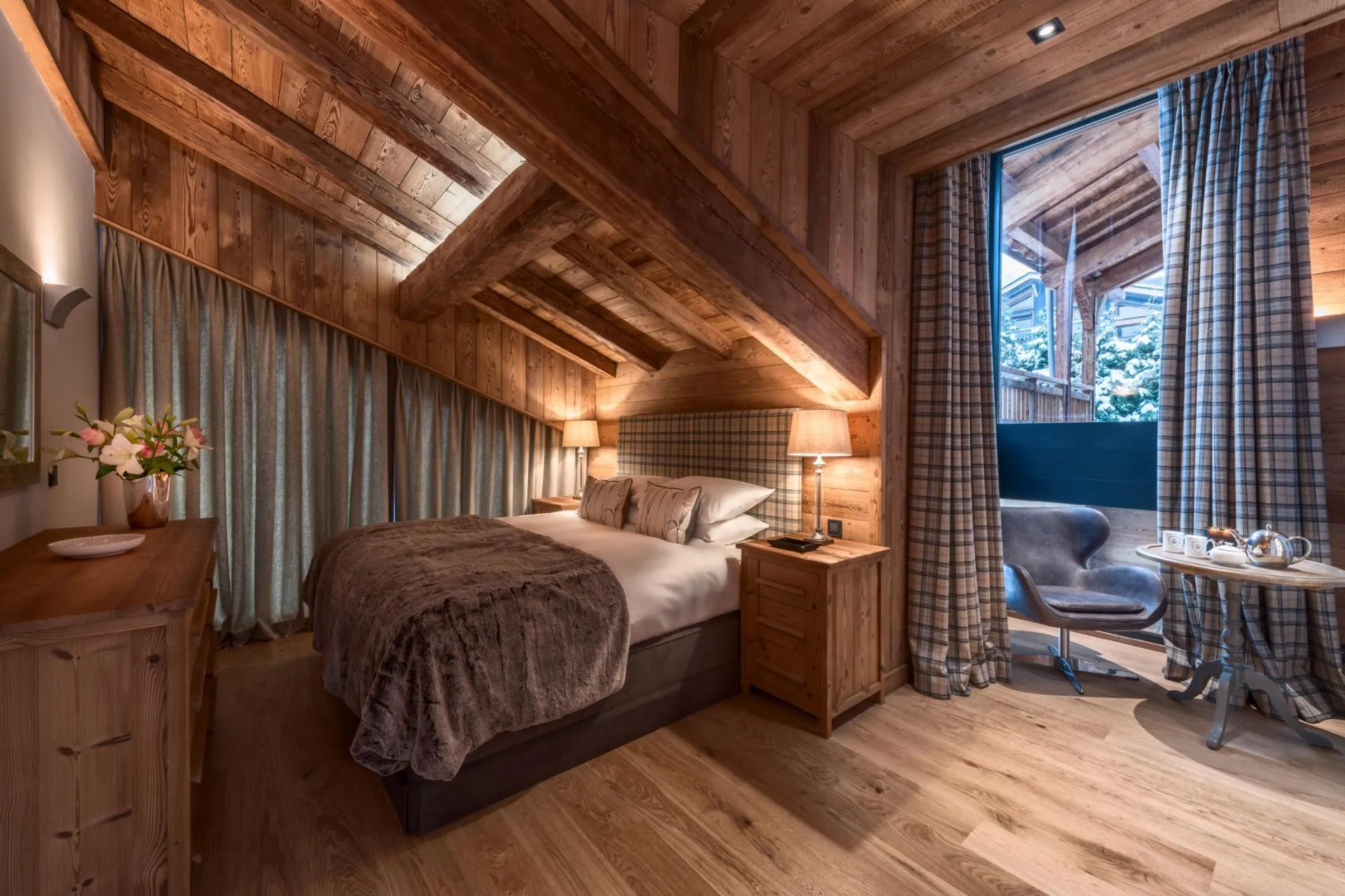 Top-floor bedroom with vaulted timber ceilings and private balcony access
