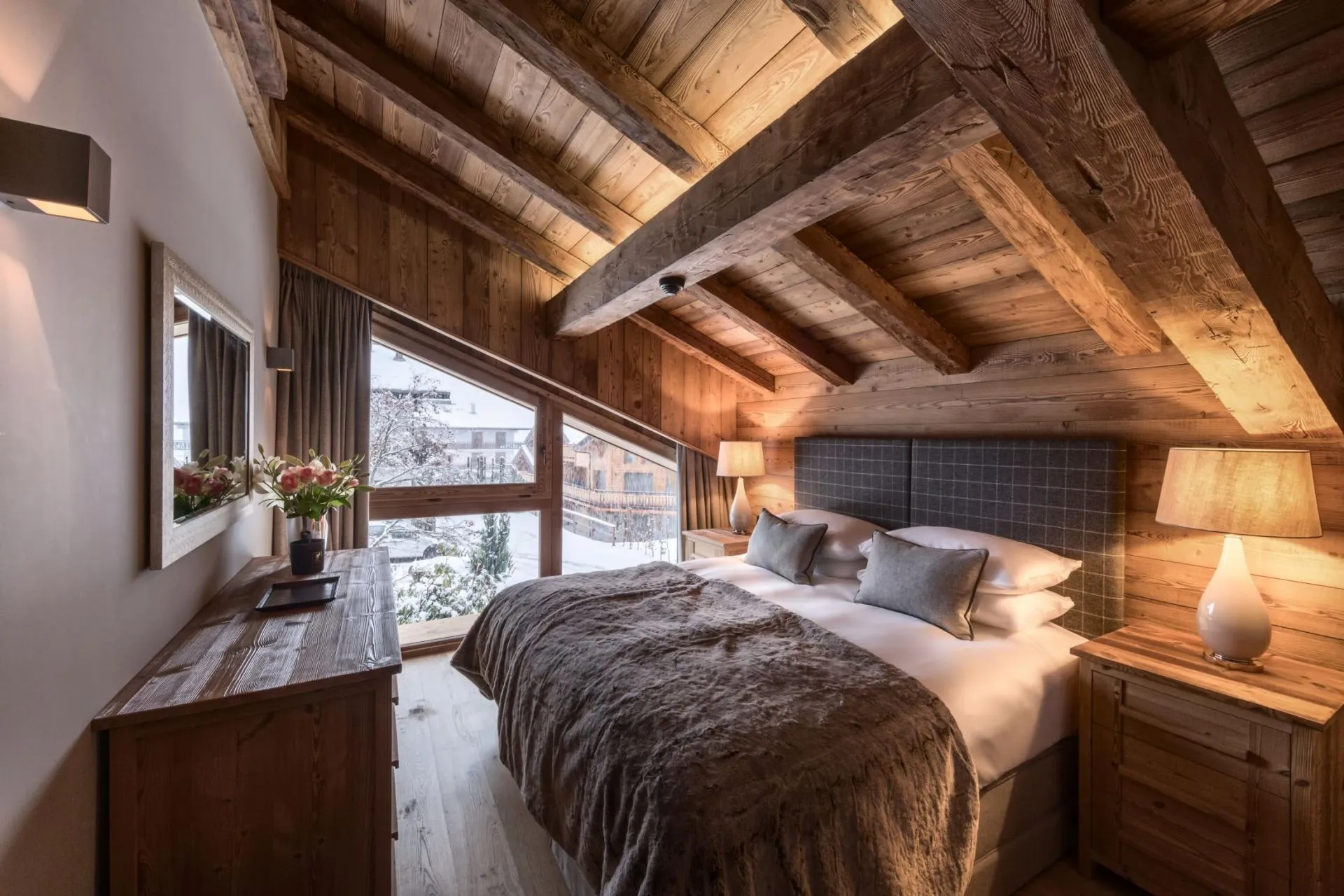 Upper-level bedroom with king bed and vaulted timber ceilings