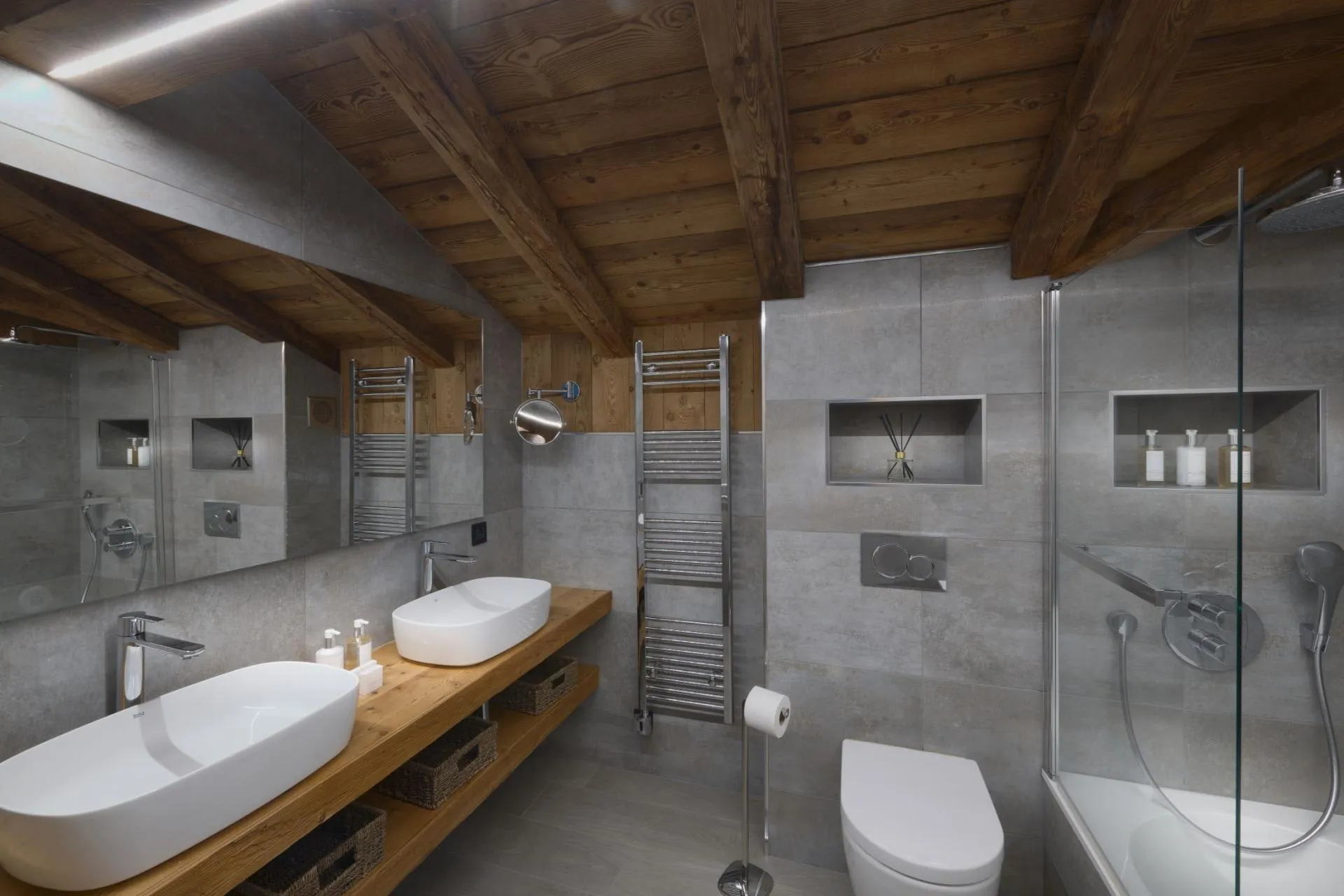 Bathroom with dual vessel sinks, walk-in shower, and heated towel rack