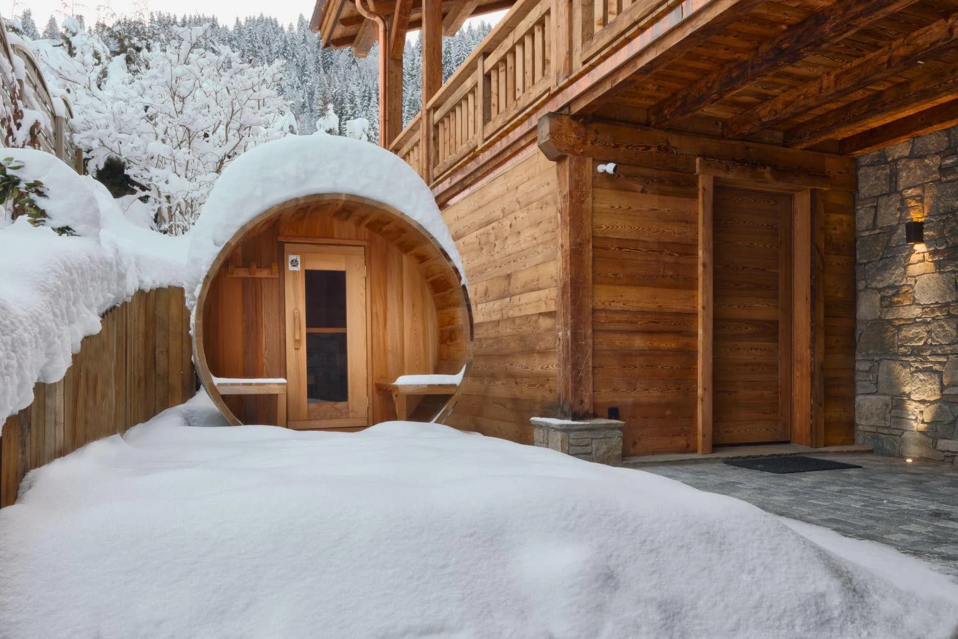 Outdoor barrel sauna with covered porch and integrated changing benches