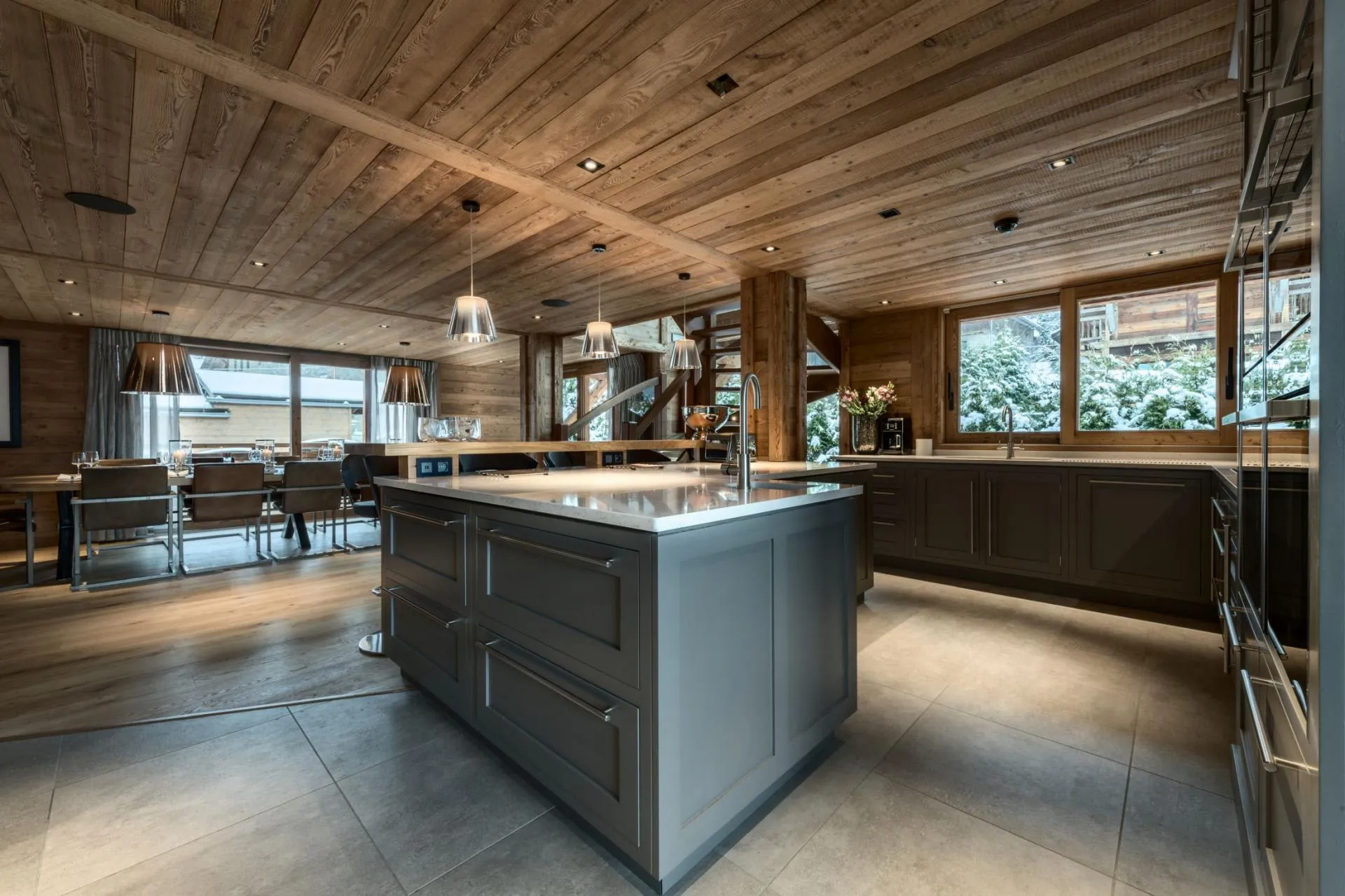 Kitchen island with prep sink; breakfast bar and dining area beyond