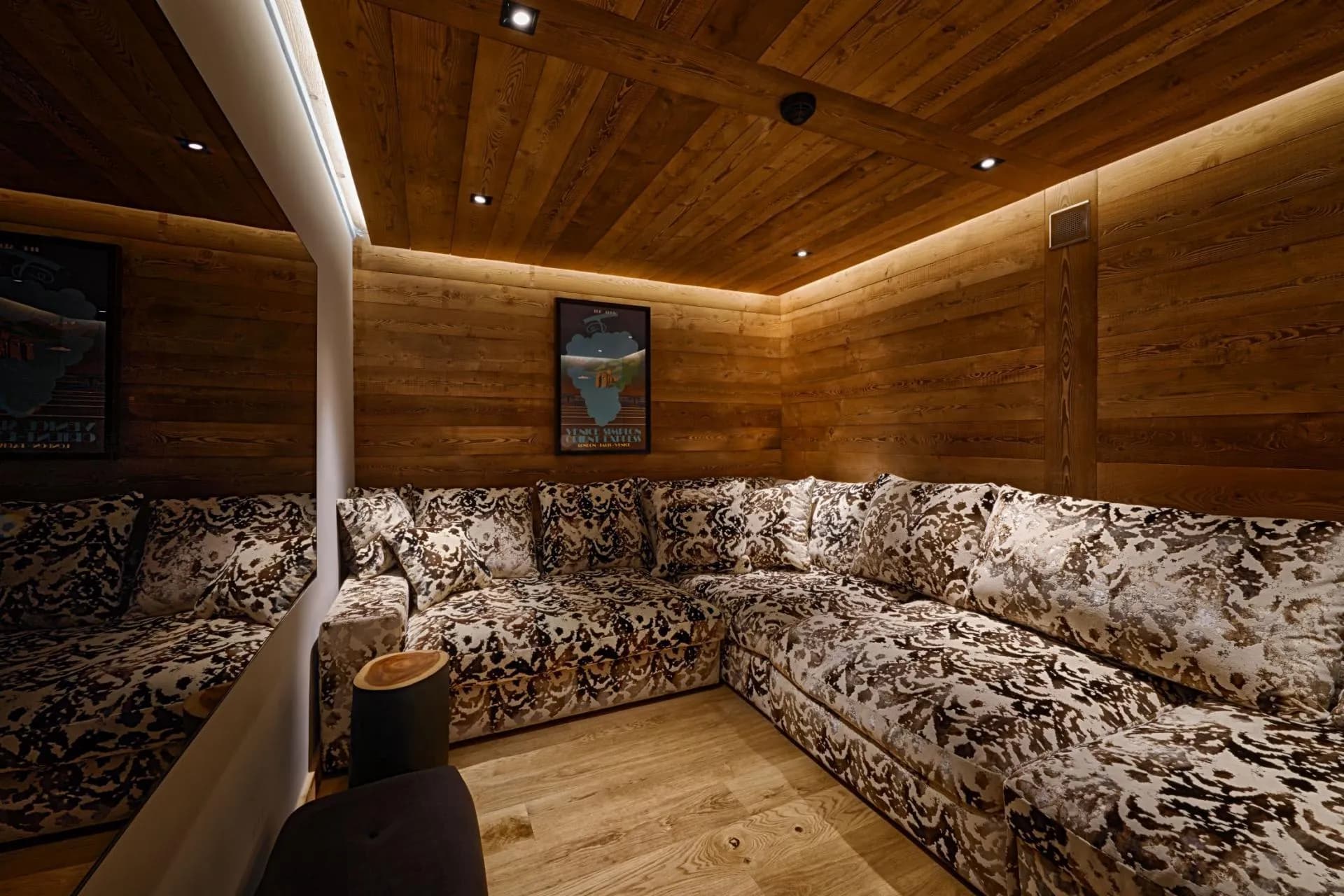 Media room with corner sofa seating and reclaimed wood paneled walls
