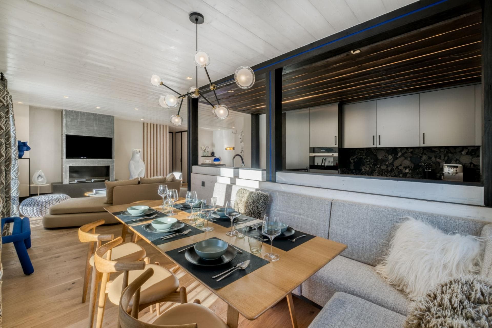 Dining area with banquette seating; view of kitchen and living room fireplace