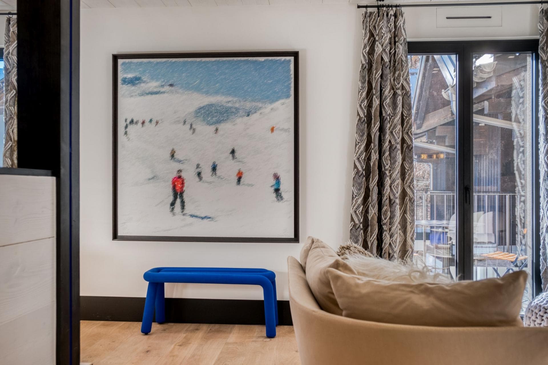Living area with ski-themed artwork and private balcony access