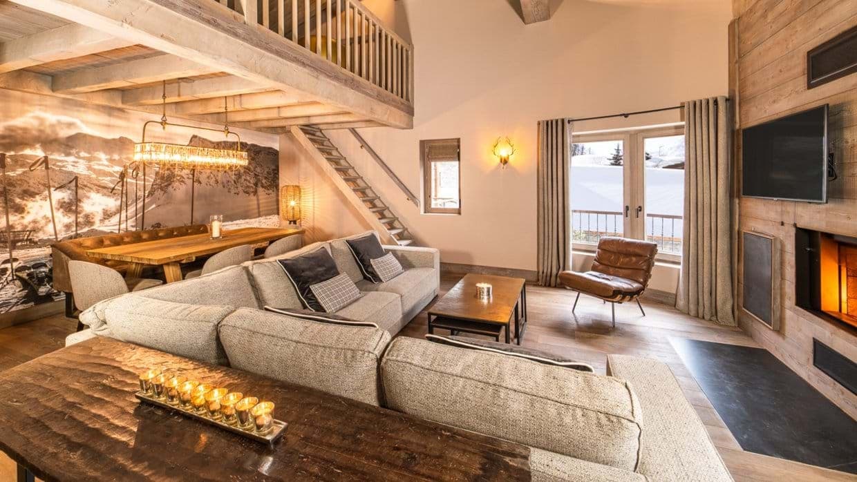 Living area with fireplace, sectional seating, and mezzanine loft access