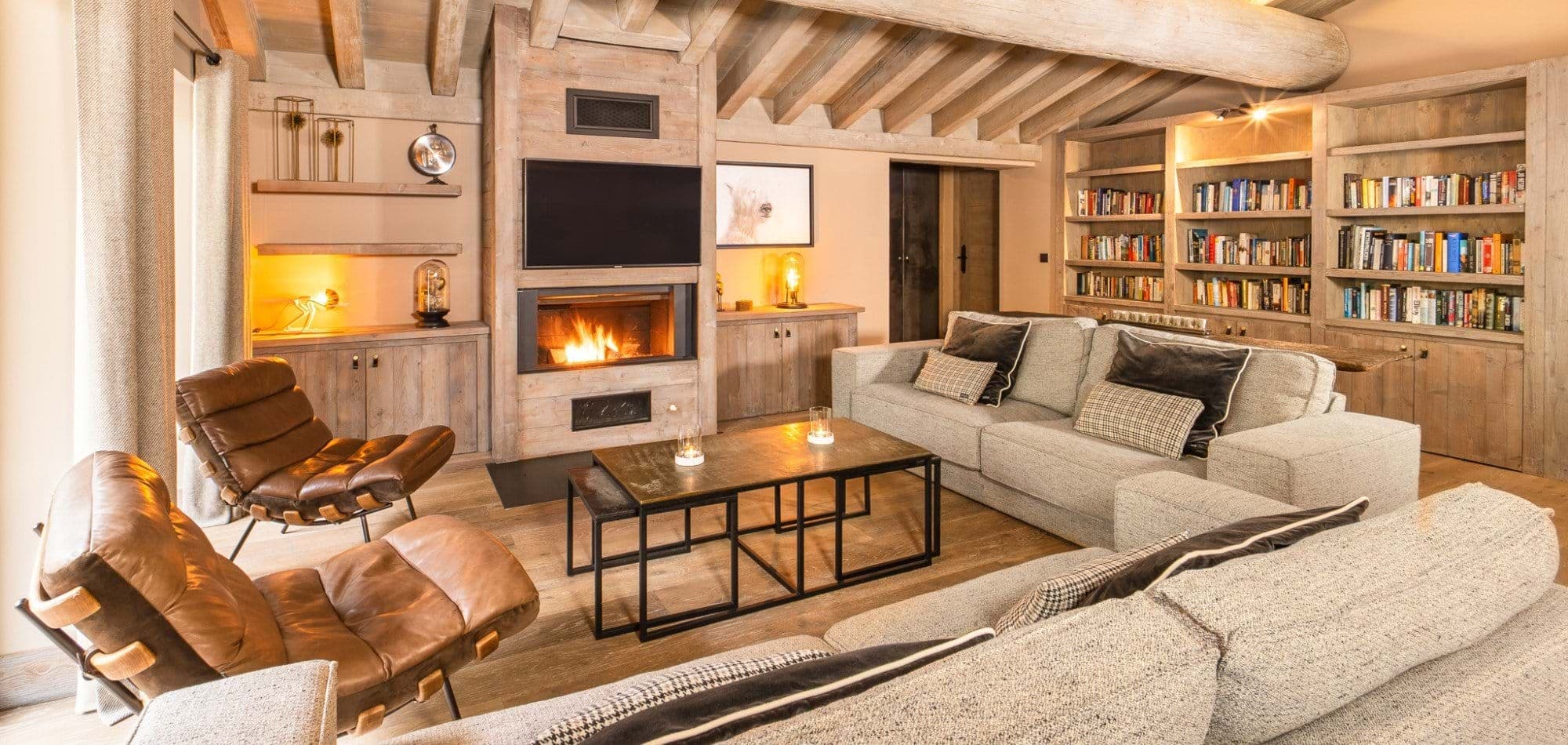 Living area with wood-burning fireplace and floor-to-ceiling library shelving