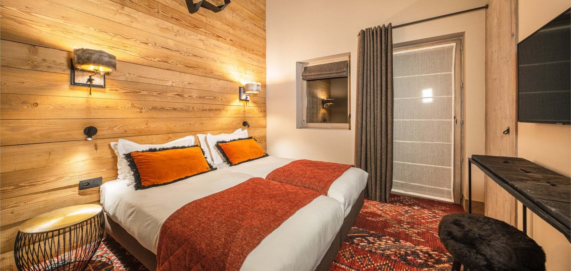Guest bedroom with two twin beds and wood-paneled feature wall