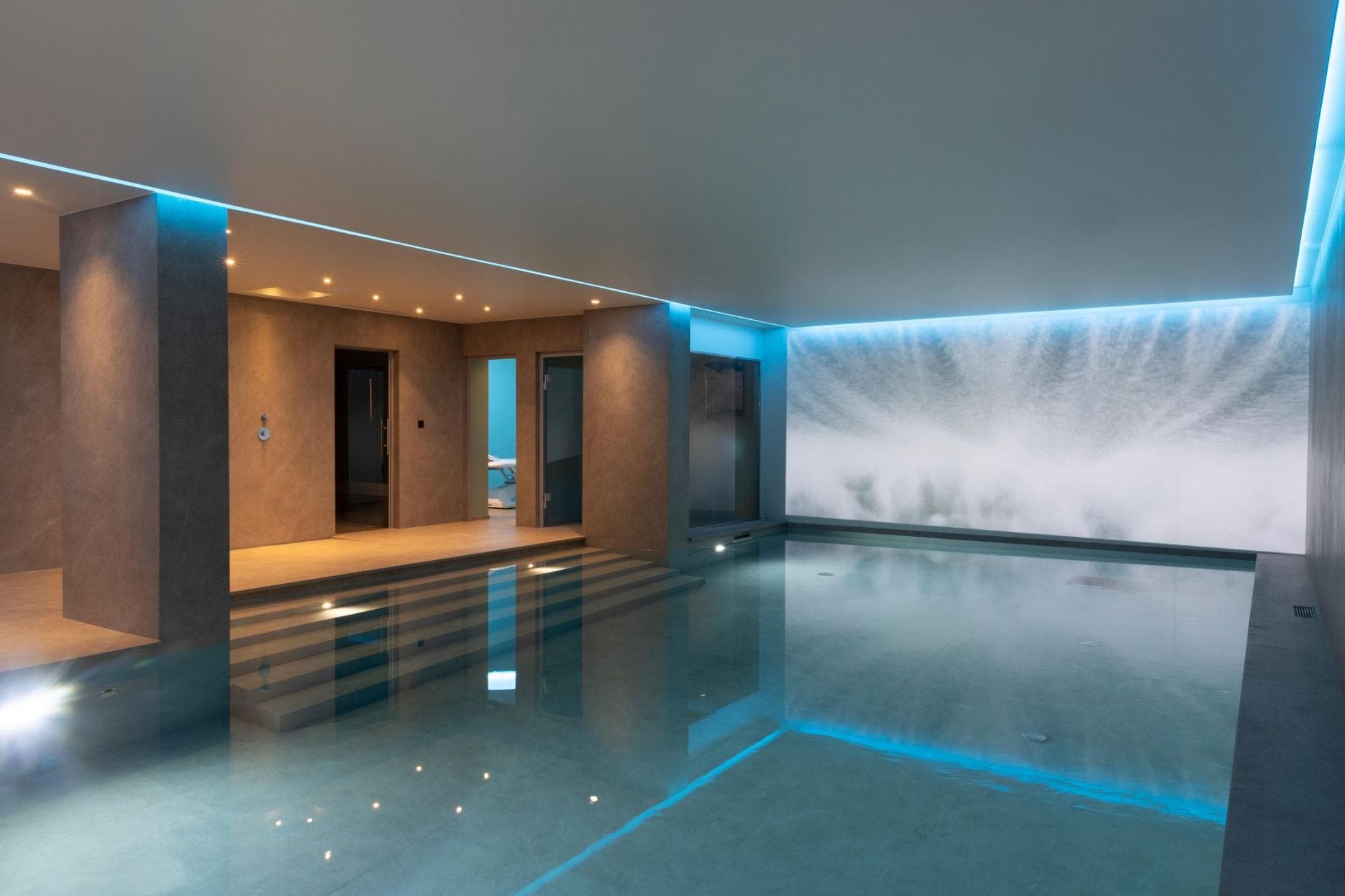 Indoor heated pool with integrated sauna and steam room access