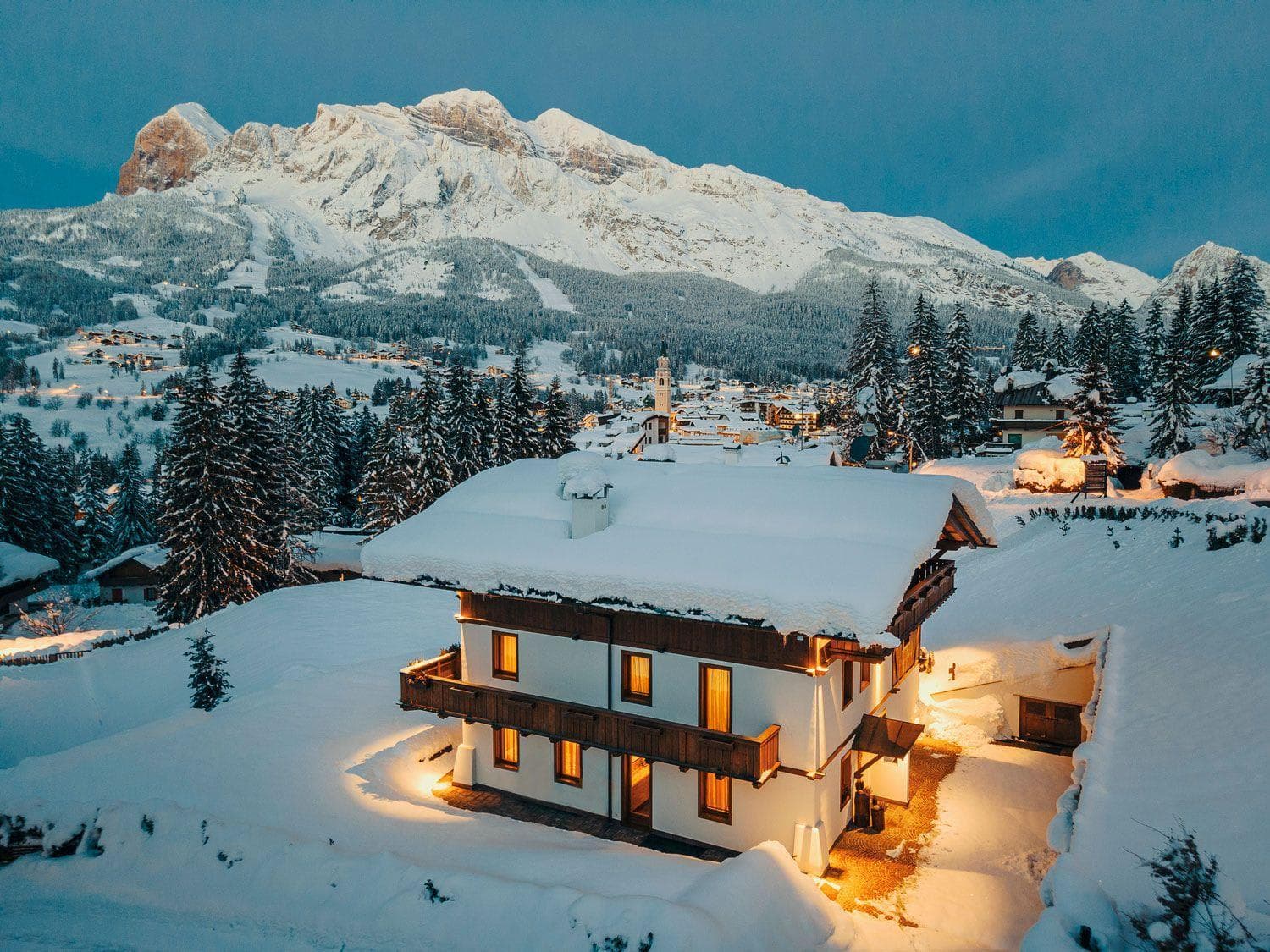 Chalet exterior at dusk with mountain views and village proximity