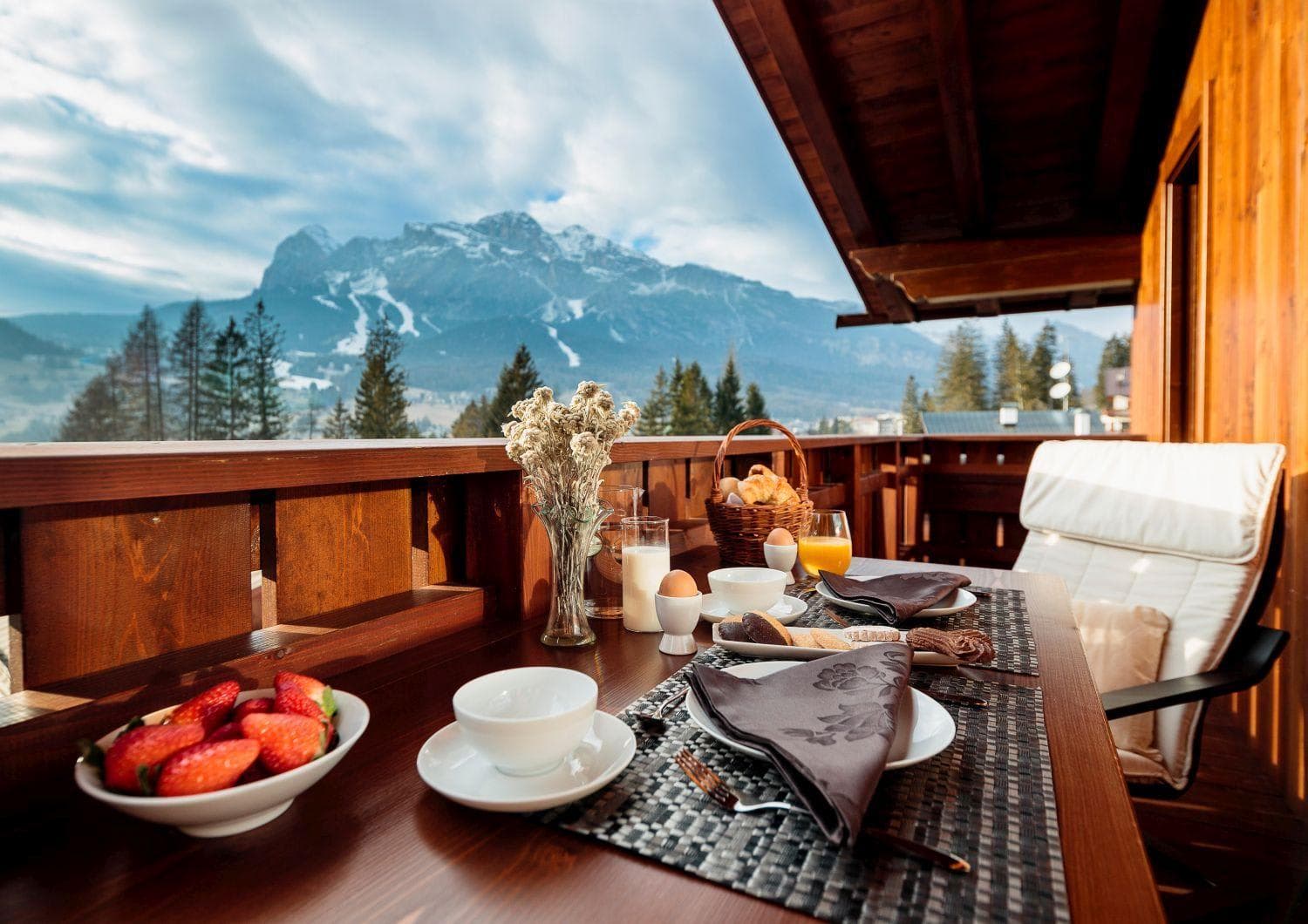 Covered balcony with dining table and views of the Dolomites