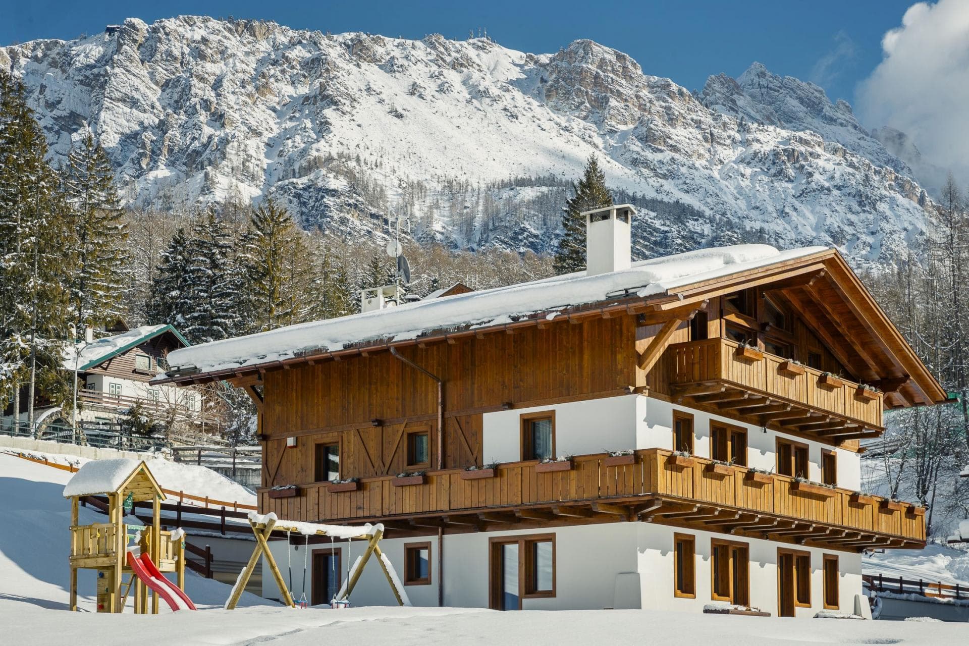 Chalet exterior with wrap-around balconies and private children's playground