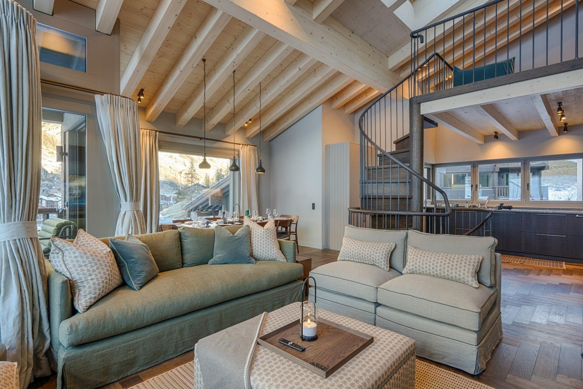 Open-plan living area with spiral staircase and vaulted timber ceilings