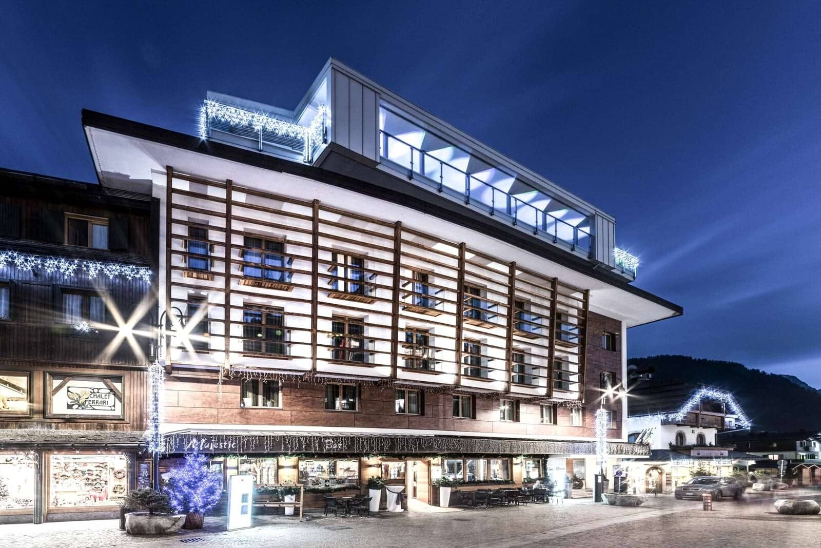 Chalet exterior featuring private balconies and ground-floor bar with outdoor seating