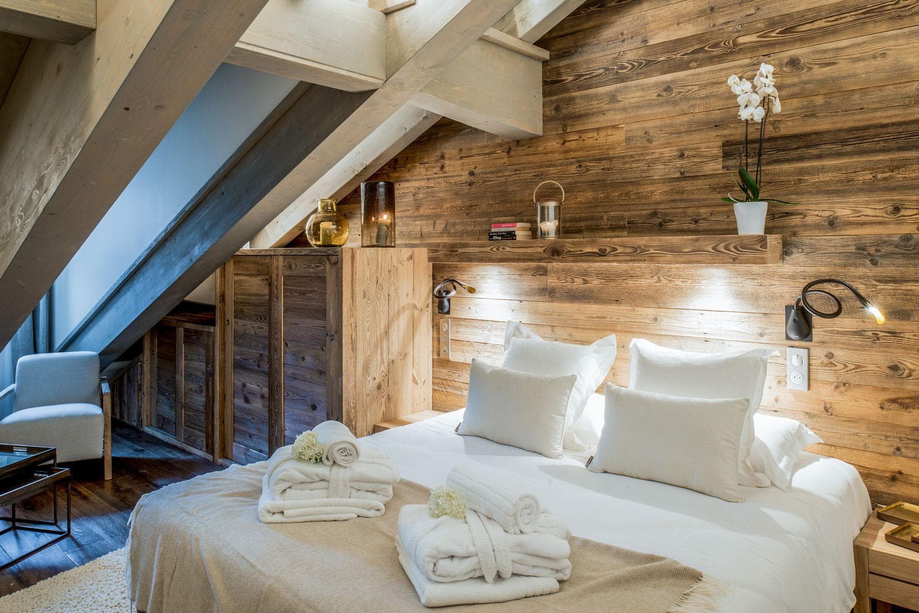 Attic bedroom with reclaimed wood walls and built-in reading lights