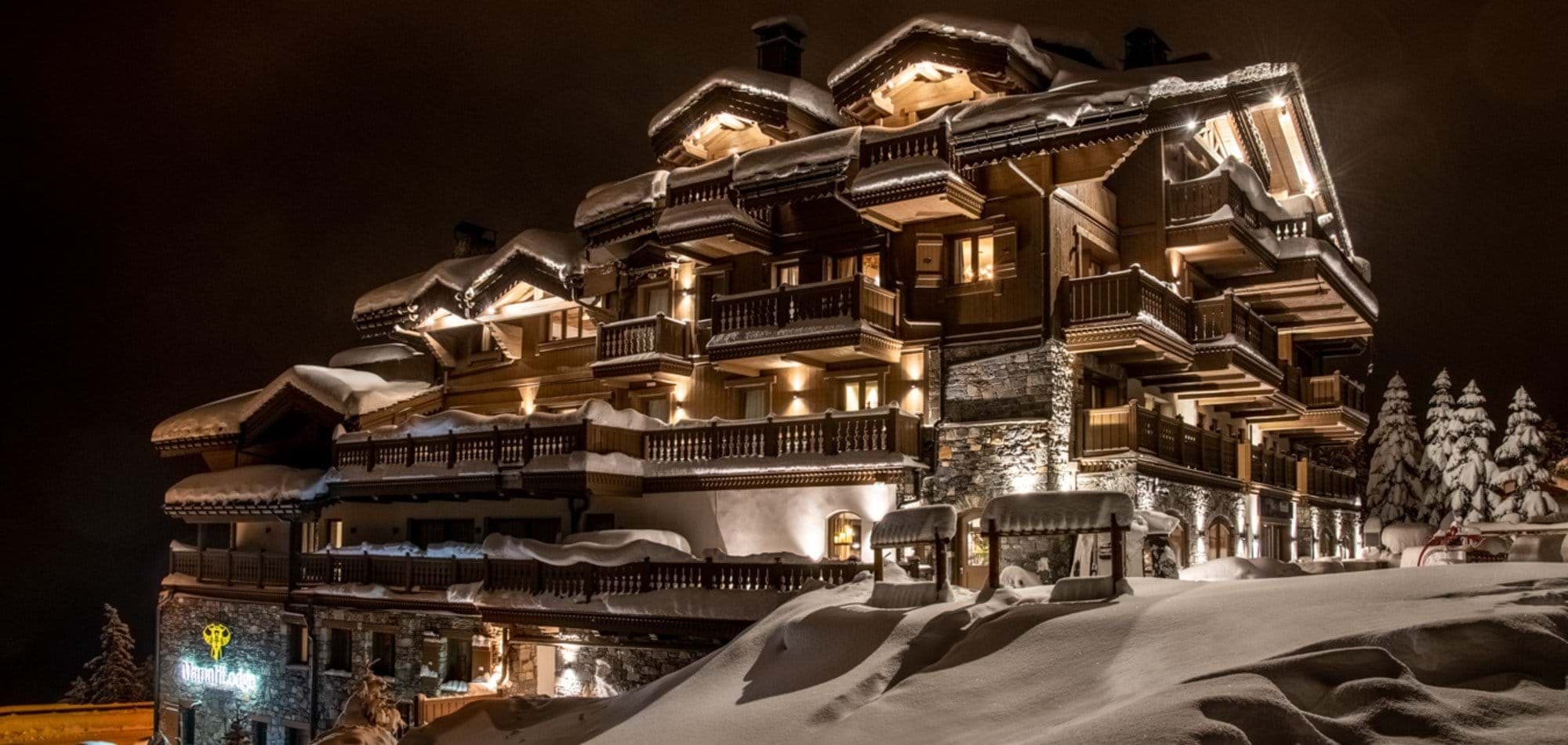 Ski-in/ski-out chalet exterior featuring multiple private balconies and stone masonry