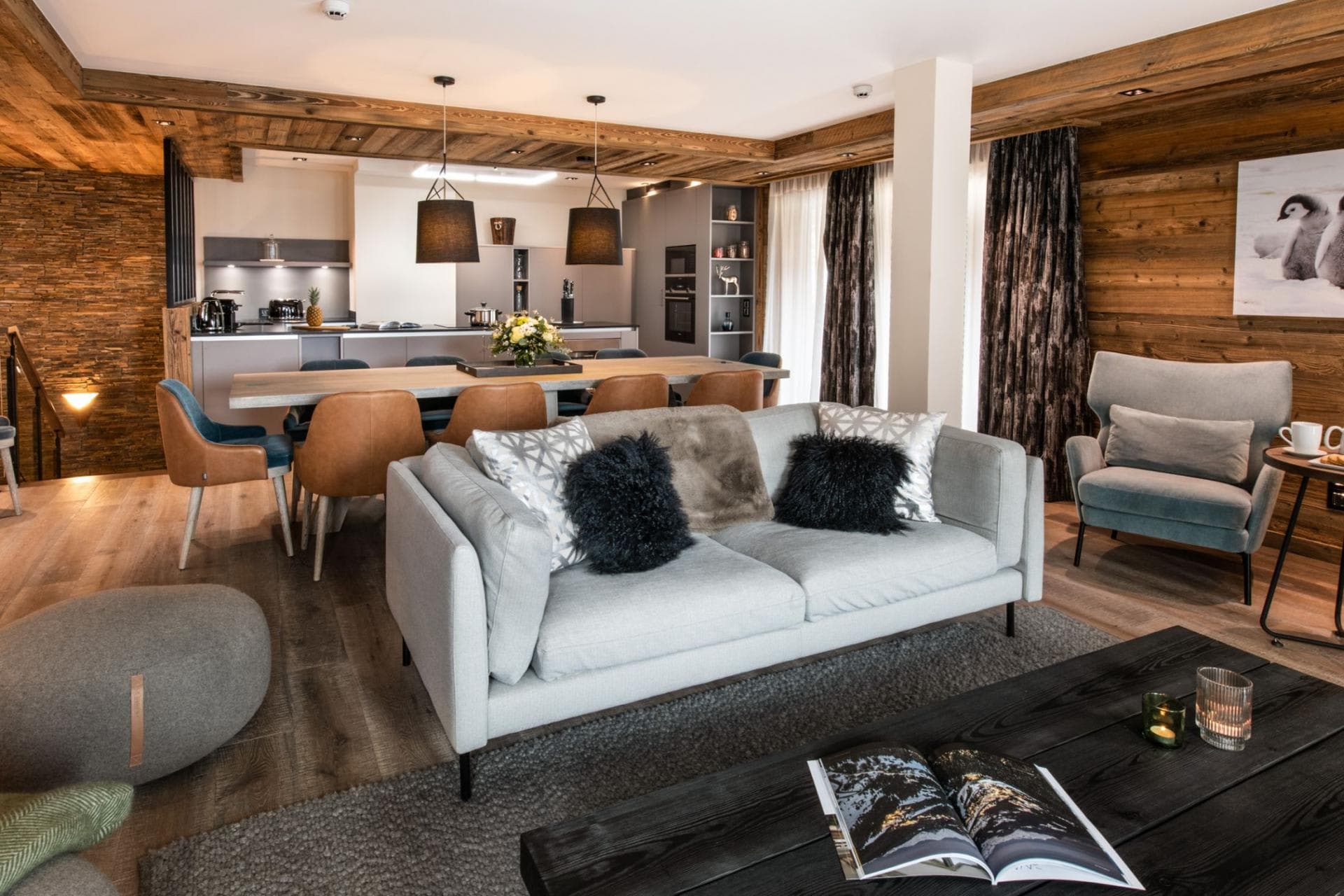 Open-concept living space with rustic wood walls and dining seating for 8