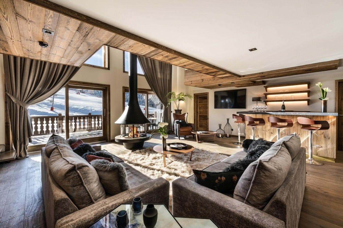 Living area with 360-degree fireplace, wet bar, and ski-in/ski-out views