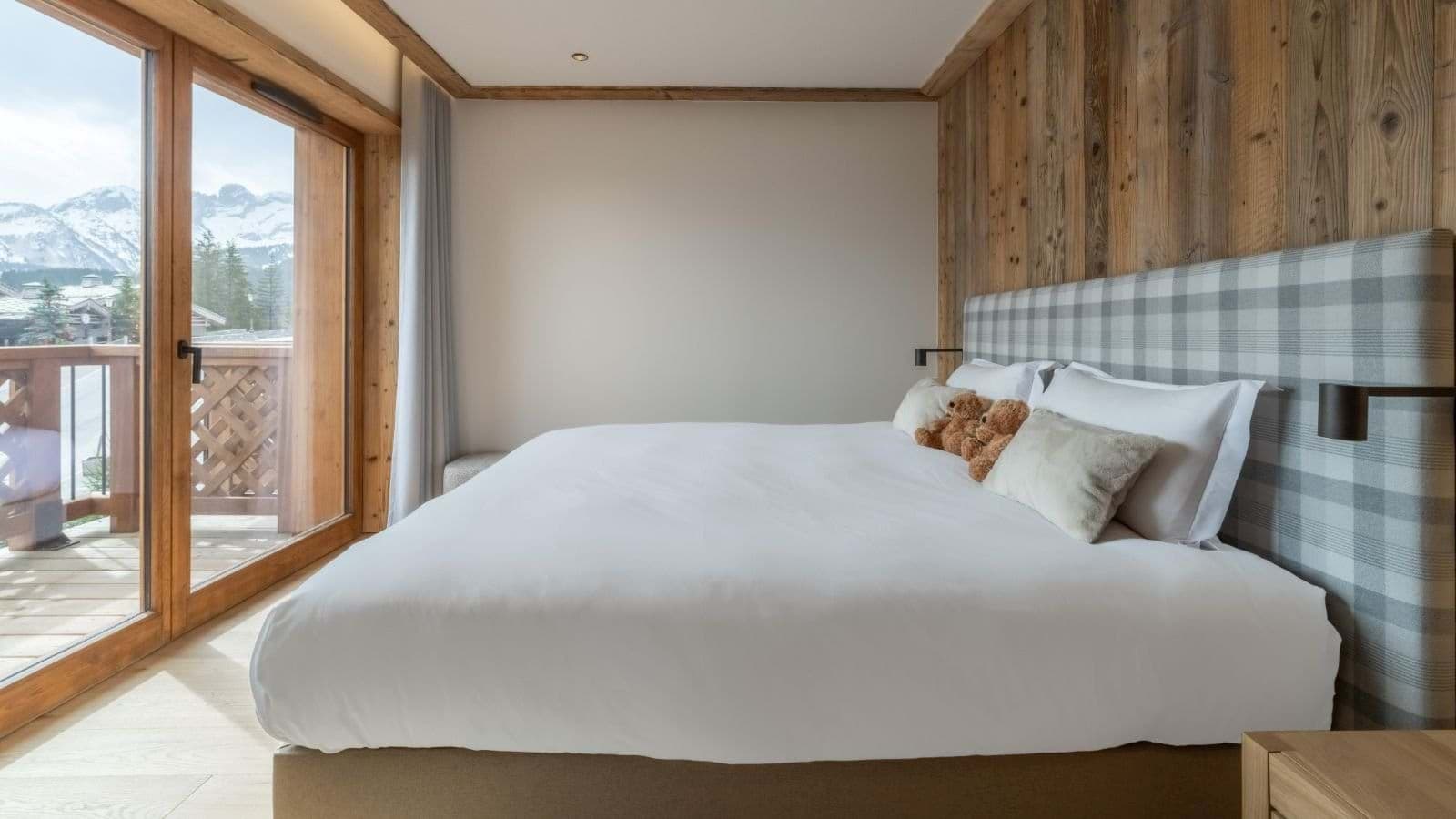 Bedroom with king bed and private balcony access to mountain views