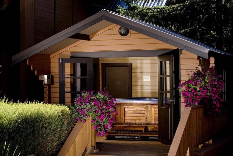 Covered outdoor hot tub with wood siding and private gazebo enclosure