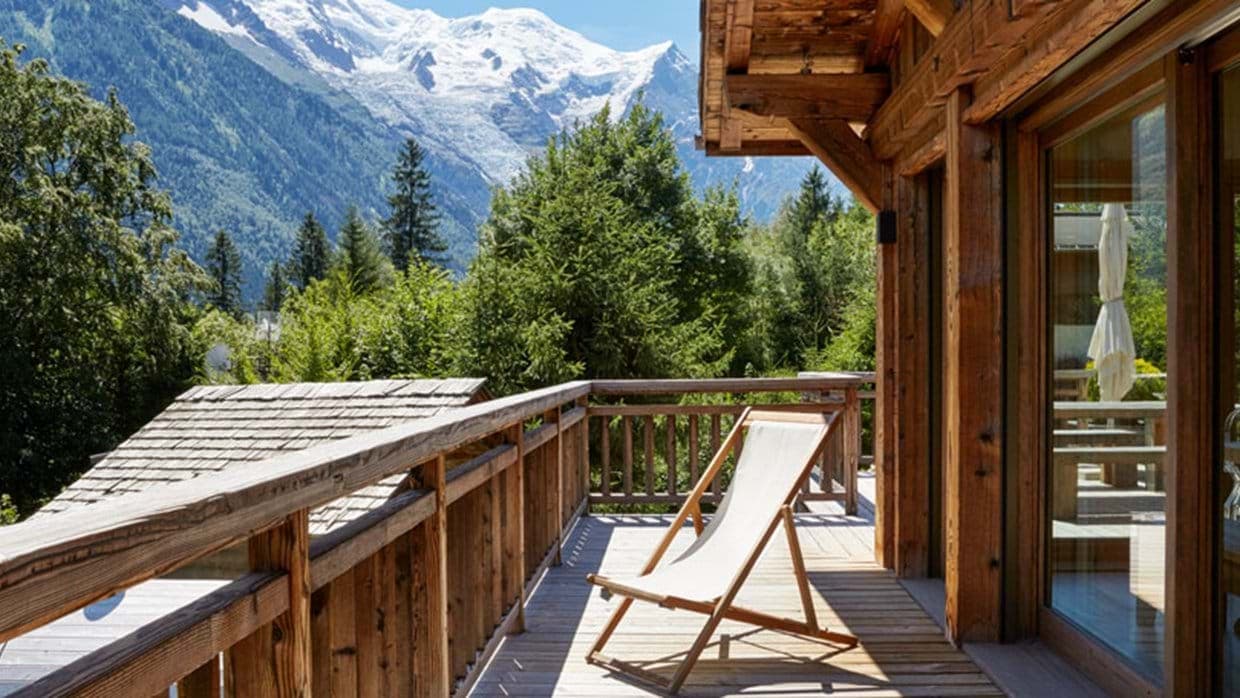 Private wooden balcony with mountain views and folding lounge chair