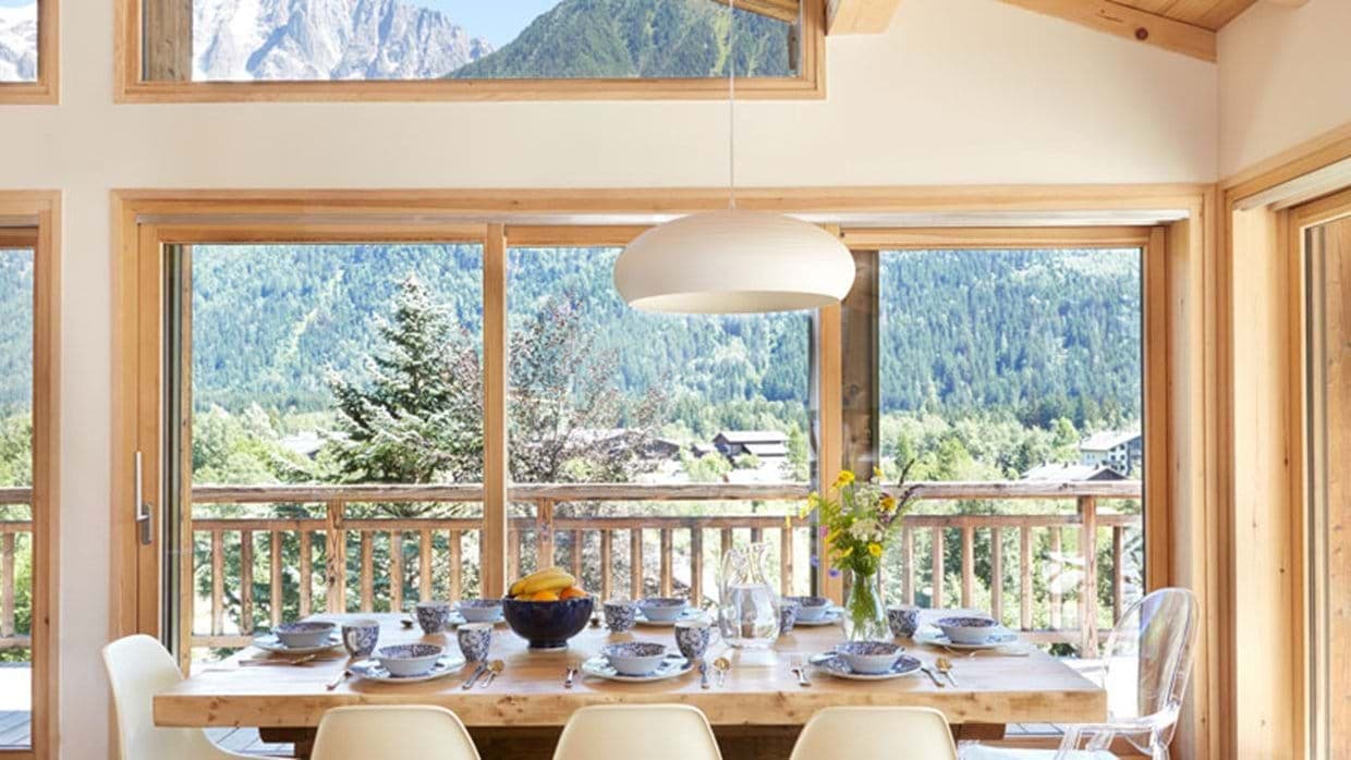 Dining area with seating for 8 and floor-to-ceiling mountain views