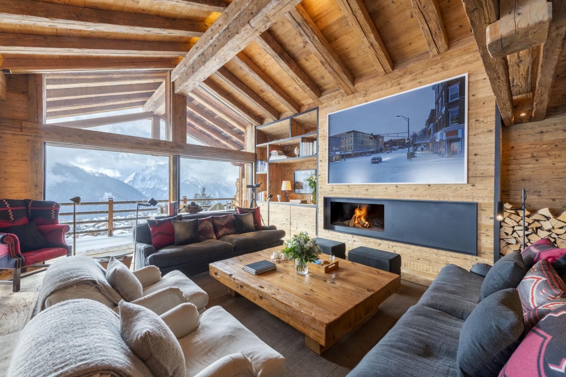 Living area with wood-burning fireplace and floor-to-ceiling mountain views
