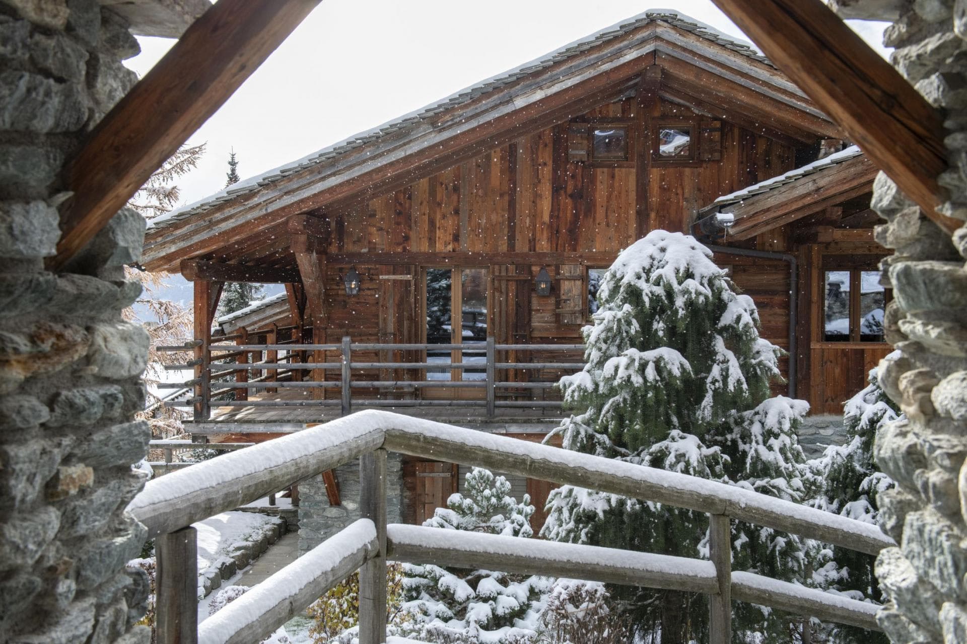Timber-framed chalet exterior with wrap-around balcony and stone entrance