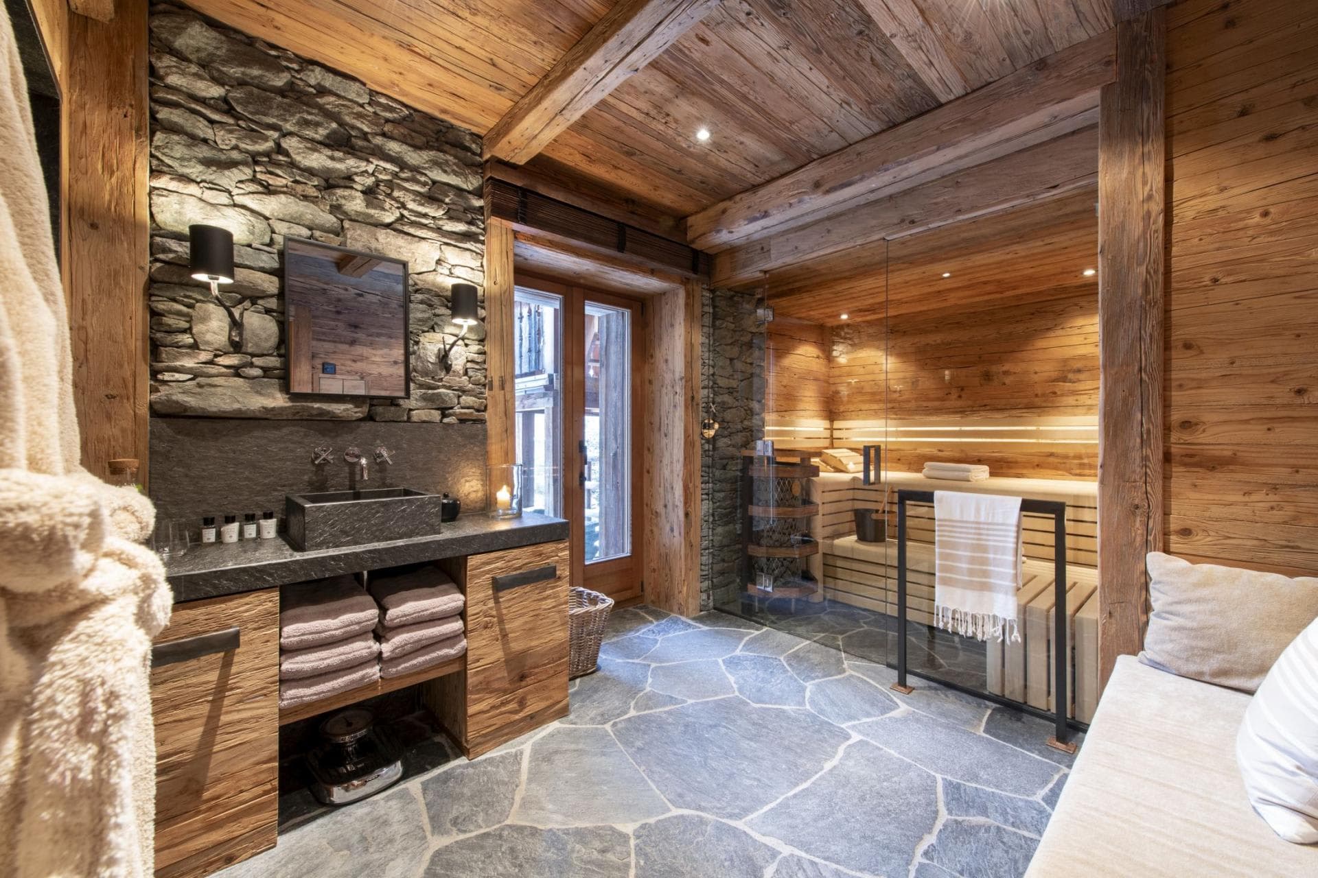 Private spa area with glass-enclosed sauna and flagstone flooring