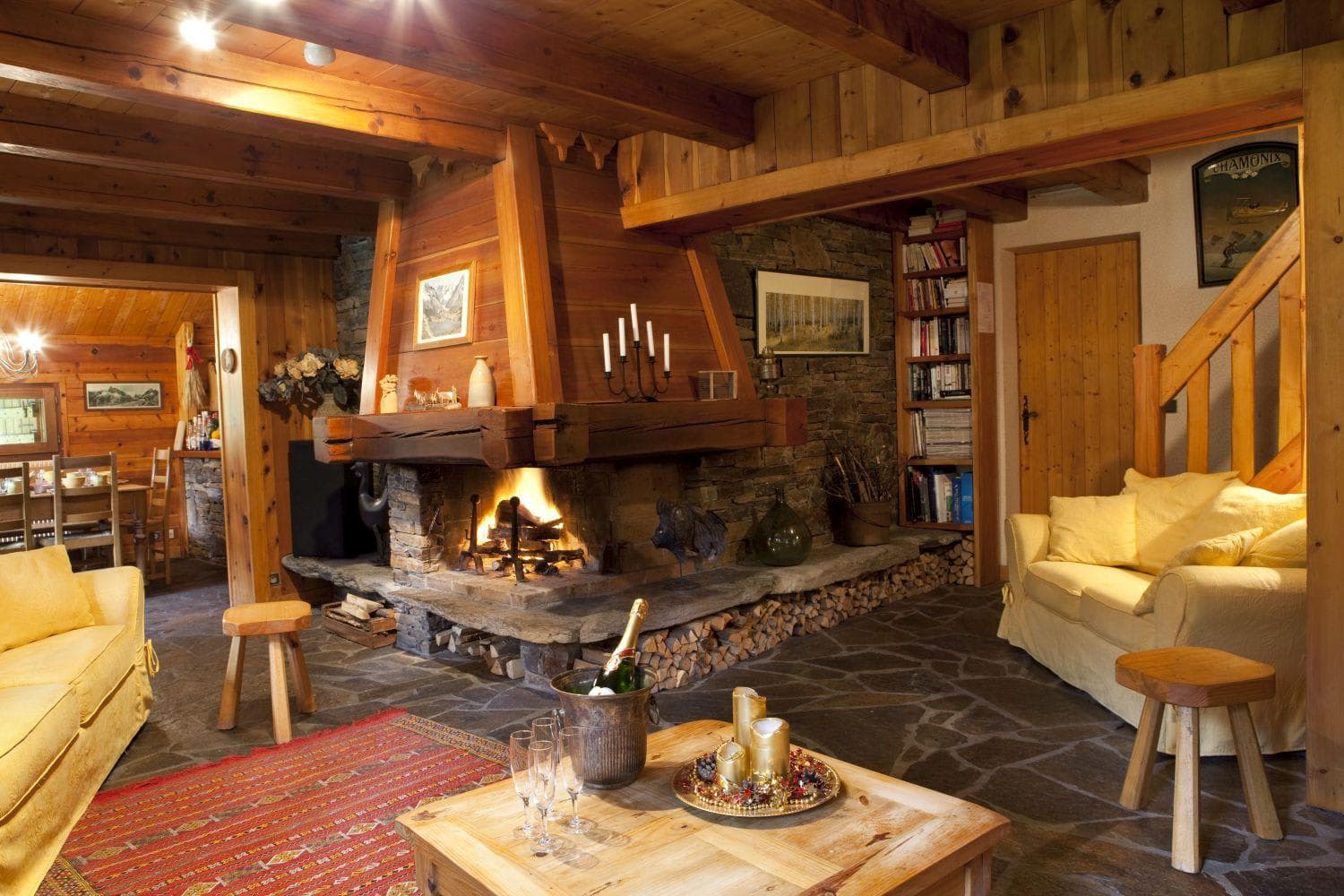 Living area with wood-burning stone fireplace and integrated log storage