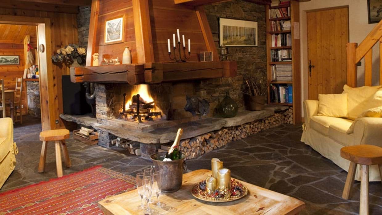 Wood-burning stone fireplace with integrated log storage and bookshelf