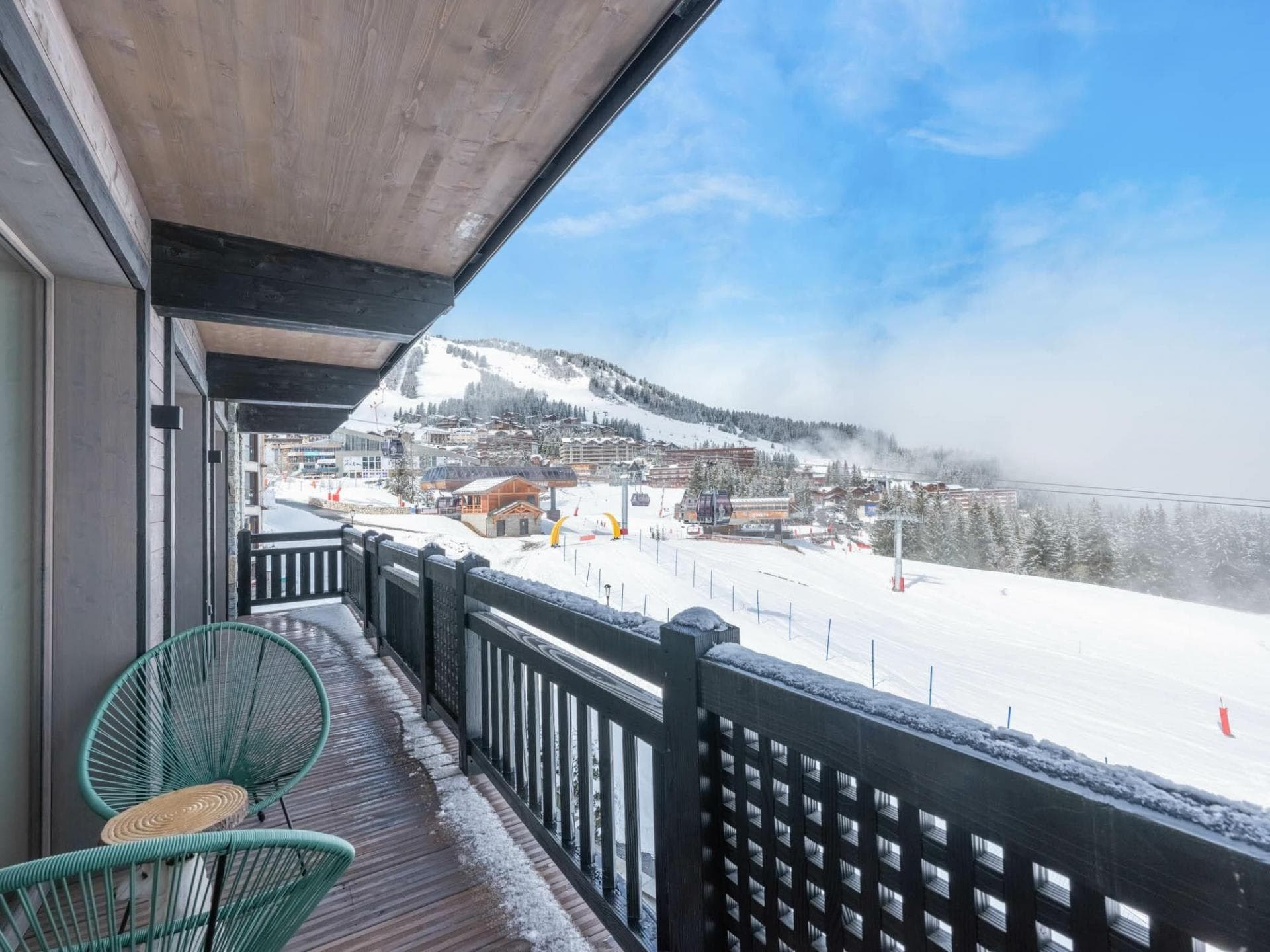 Covered balcony with Acapulco chairs and ski-in/ski-out slope views