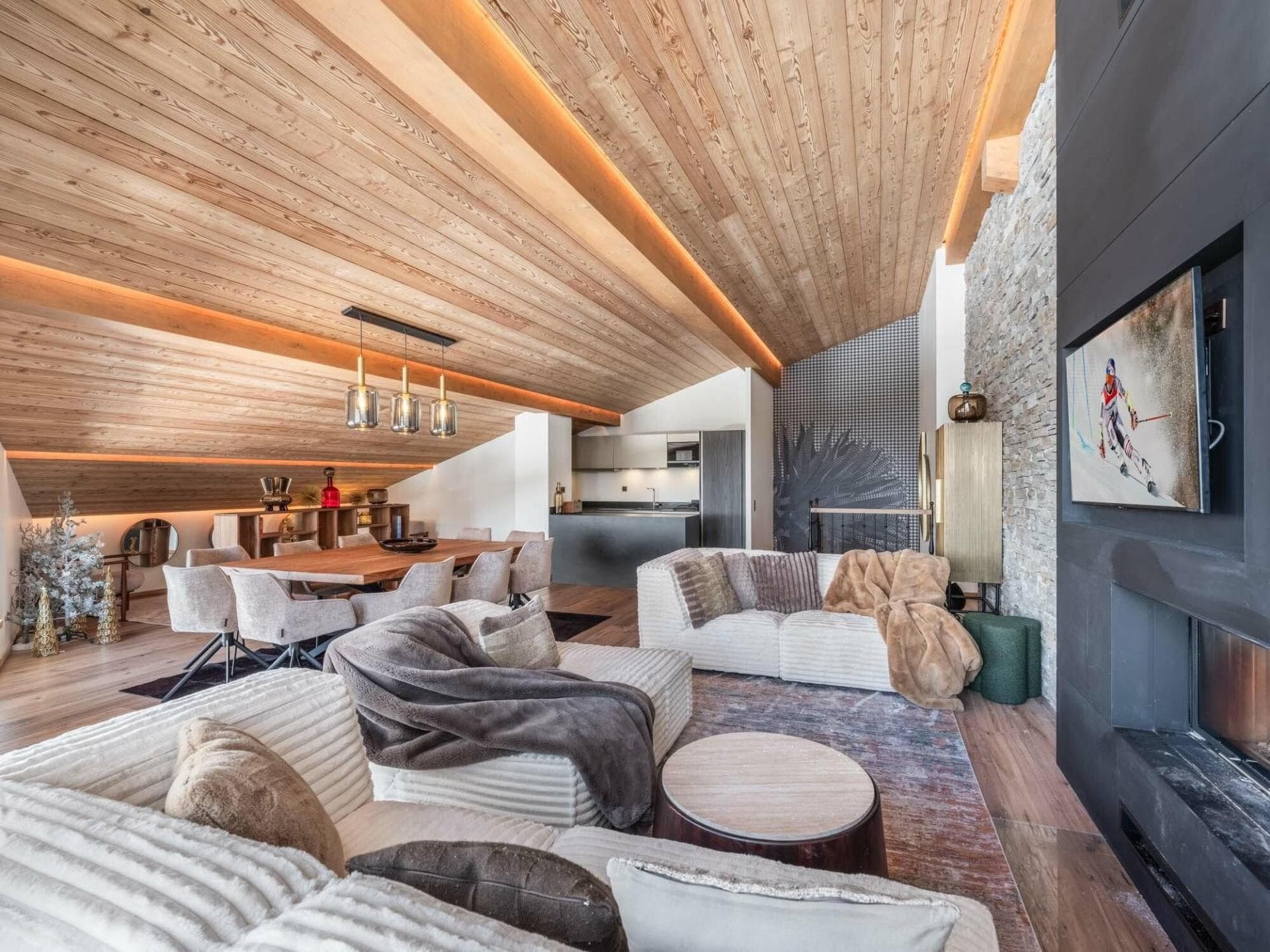 Open-plan living area with vaulted wood ceilings and dining seating for 8