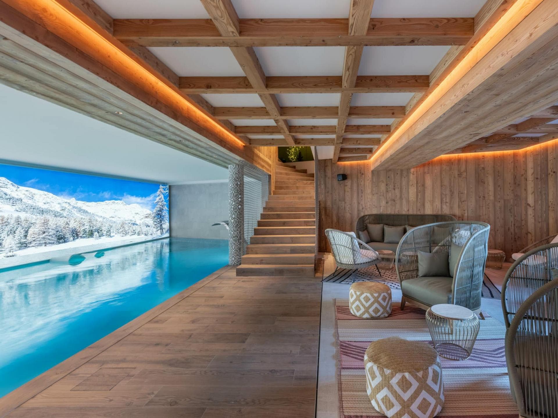 Indoor pool and lounge area with mountain views and wood-beamed ceilings